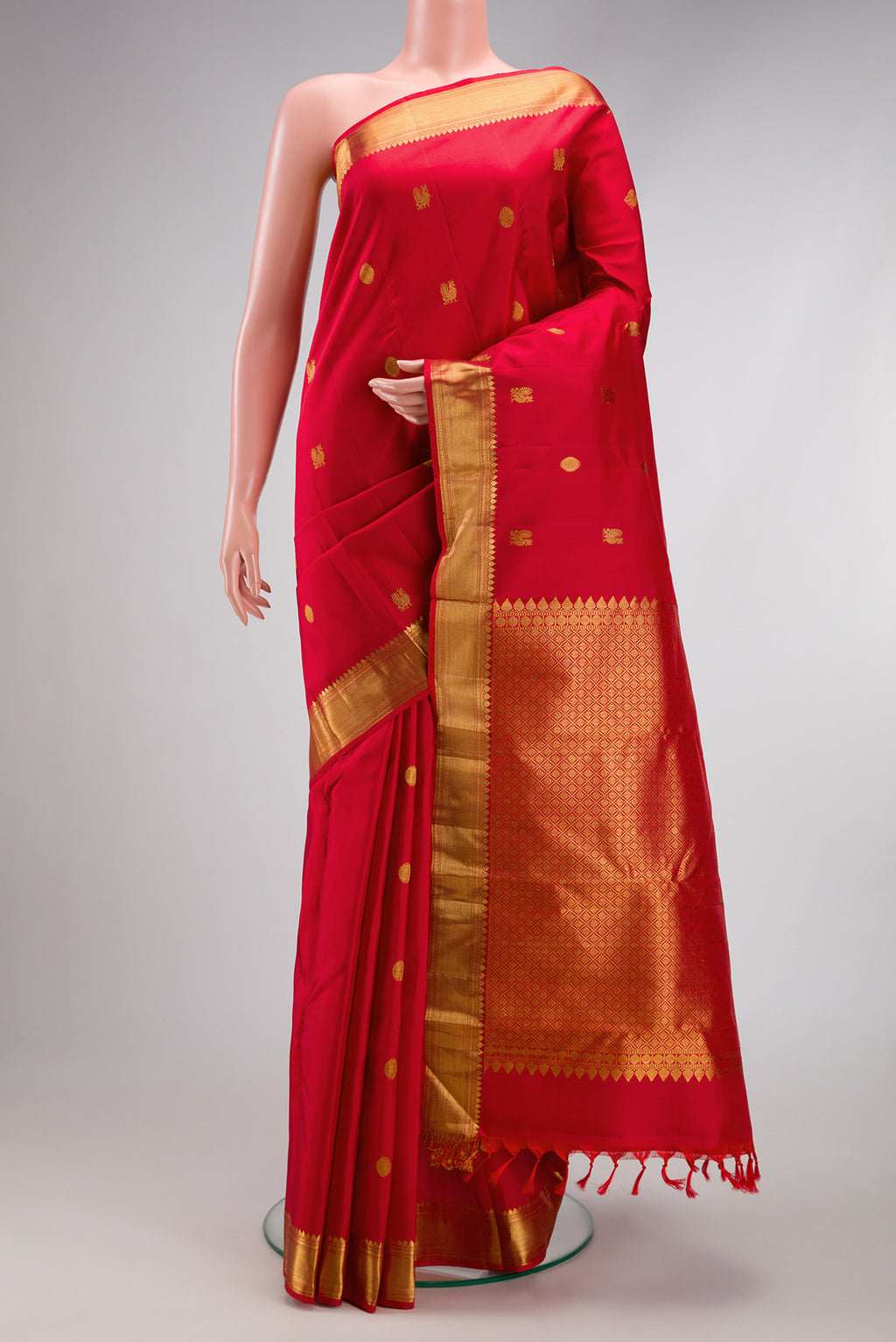 Red Kanjivaram Silk Saree with Zari Butta on the body and Zari Border.  displayed on a mannequin
