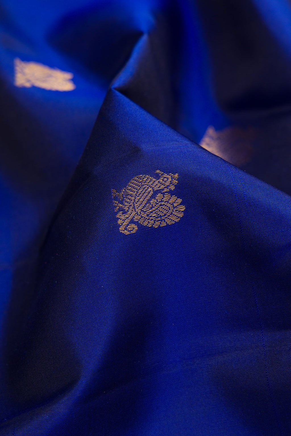 Close up of Royal Blue Dual Tone Kanjivaram Silk Saree with Zari Butta on the body and Zari Border.  displaying folds