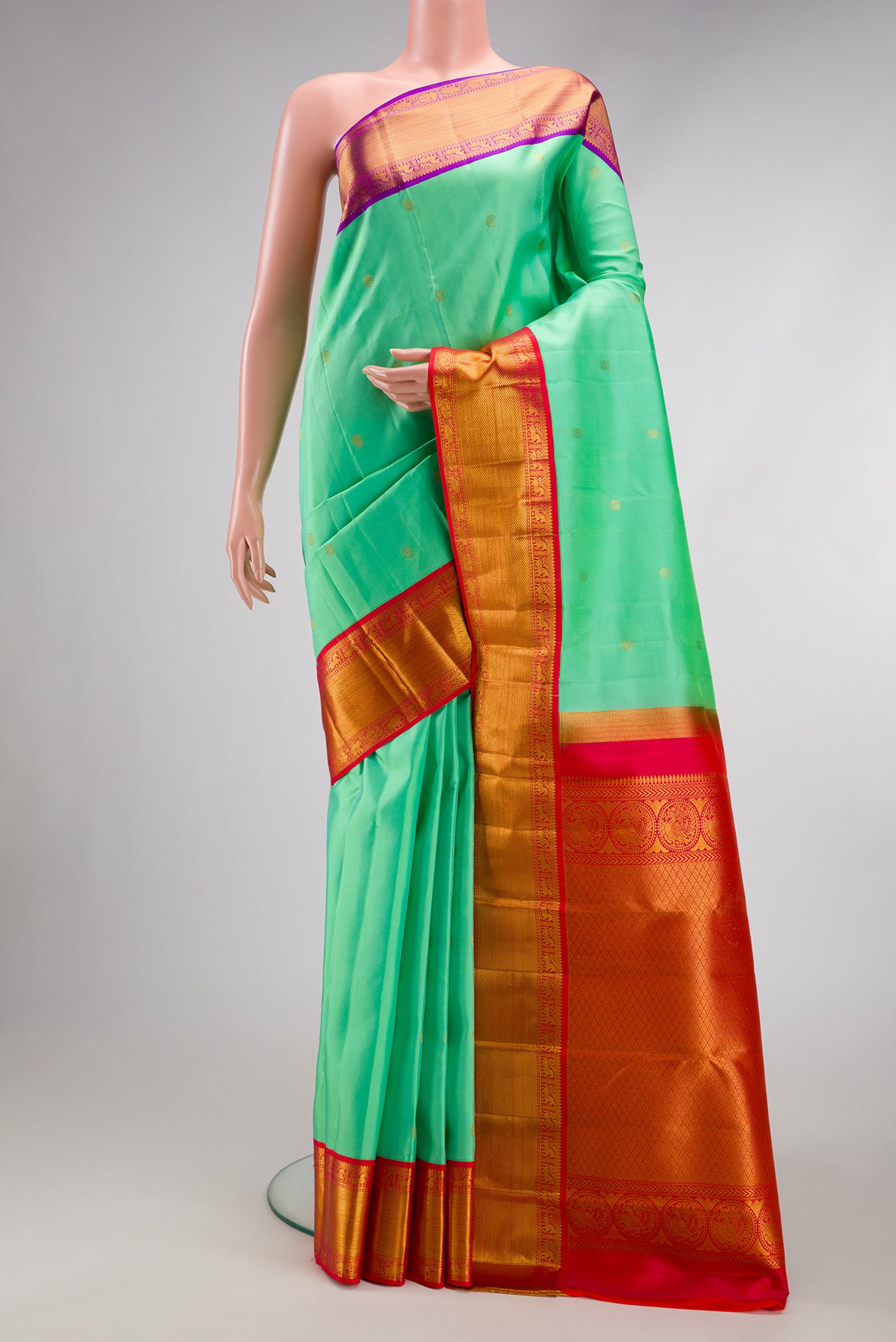 Sea Green Kanjivaram Silk Saree with Zari Butta on the body and Ganga Jamuna Border.  displayed on a mannequin