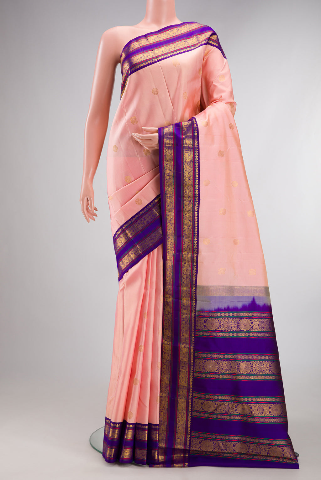 Pure Silk Peach Kanjivaram Saree with Zari Butta on the body and Zari Border.  displayed on a mannequin