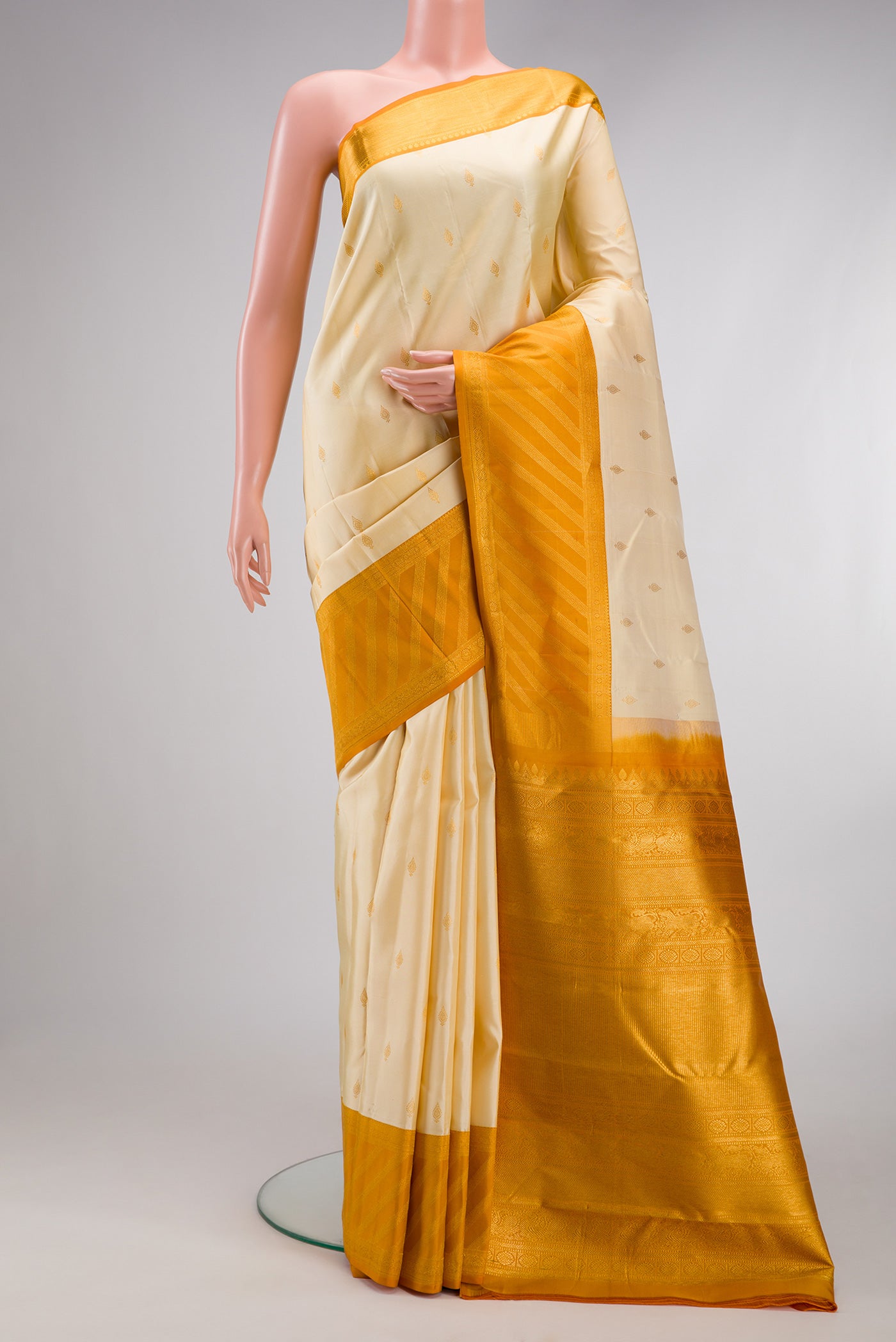 Sandal Kanjivaram Silk Saree with Zari Butta on the body and Zari Border.  displayed on a mannequin