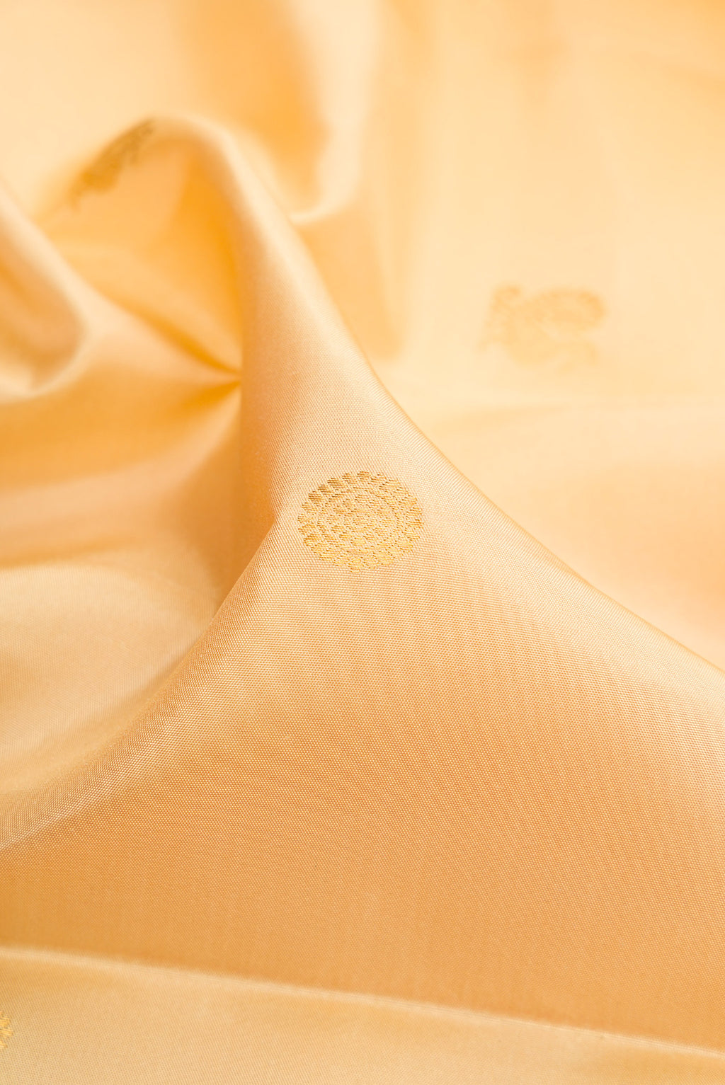 Close up of Sandal Kanjivaram Silk Saree with Zari Butta on the body and Zari Border.  displaying folds