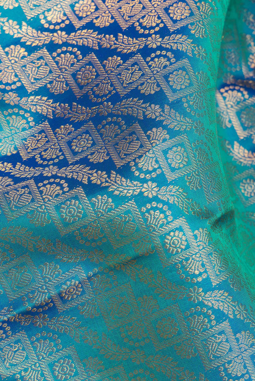 Close up of Pure Silk Peacock Blue Dual Tone Kanjivaram Saree with Zari Brocade on the body and Zari Border.  displaying folds