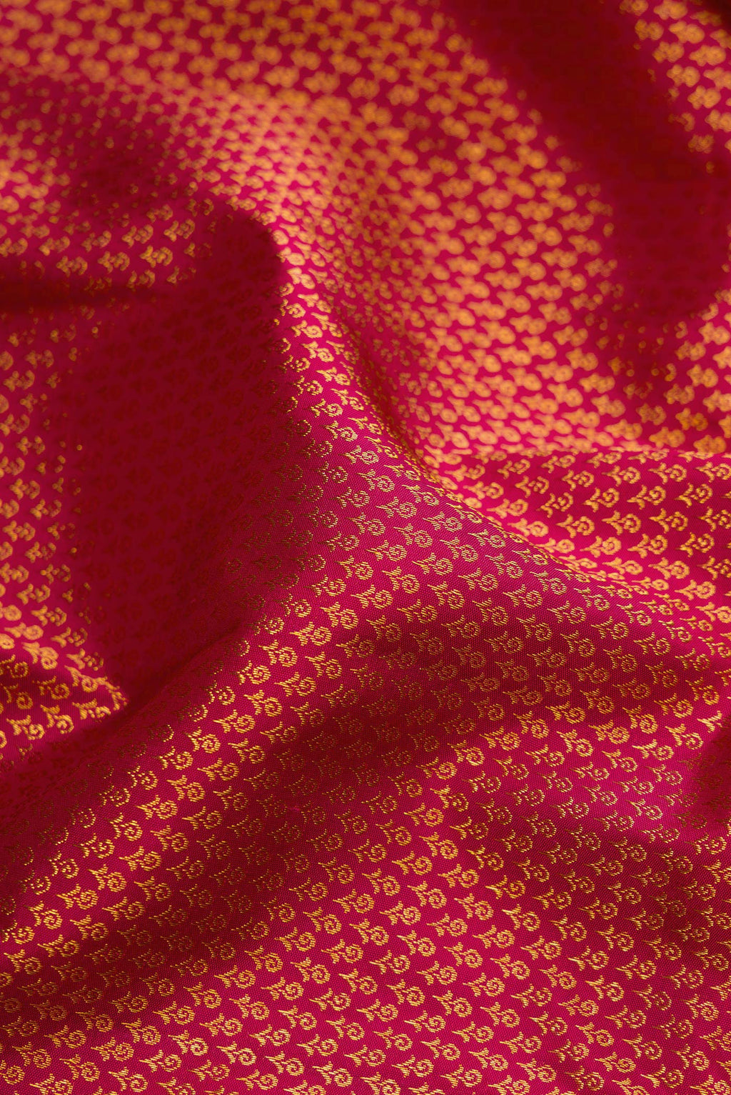 Close up of Dark Pink Kanjivaram Silk Saree with Zari Brocade on the body and Zari Border.  displaying folds