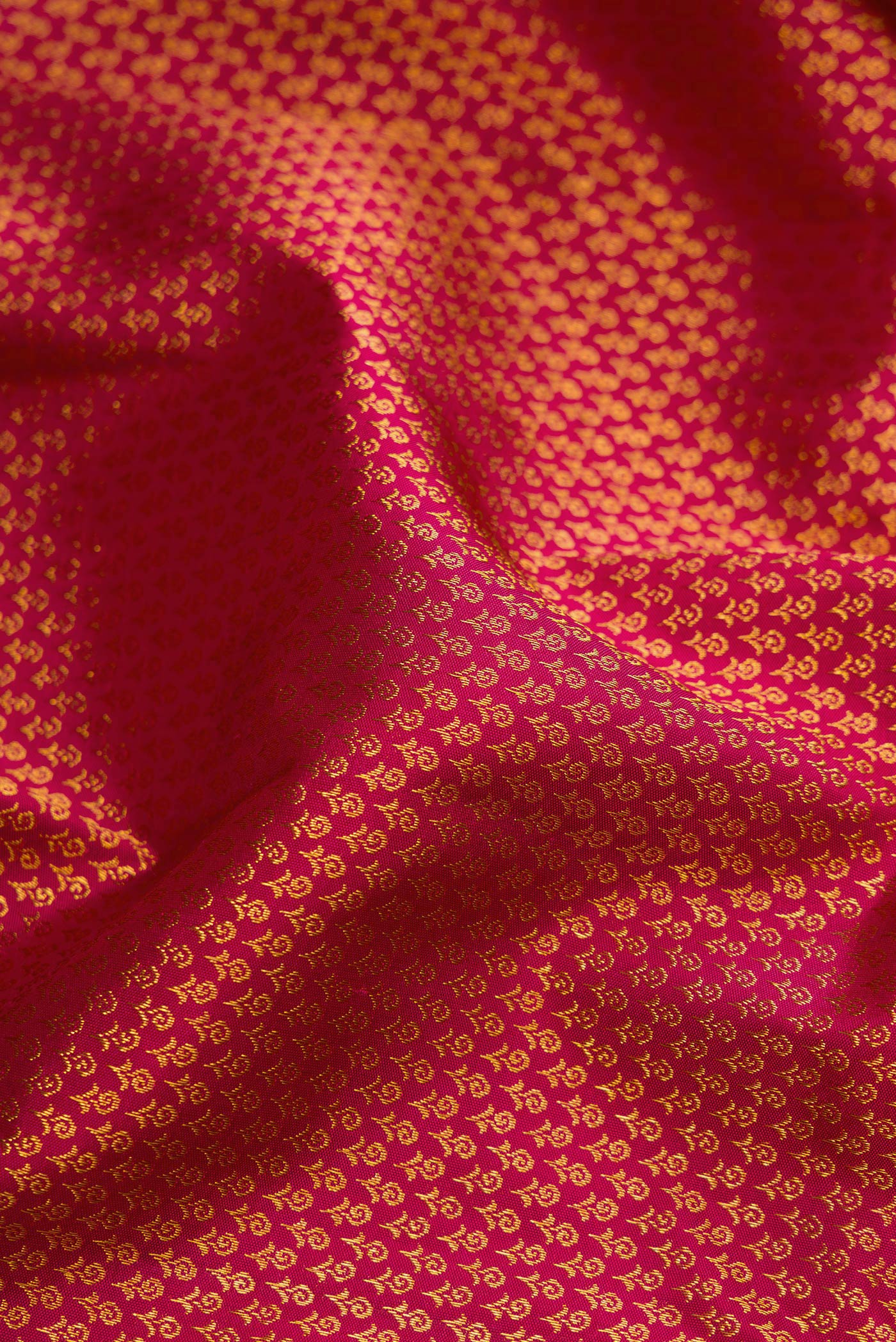 Close up of Dark Pink Kanjivaram Silk Saree with Zari Brocade on the body and Zari Border.  displaying folds