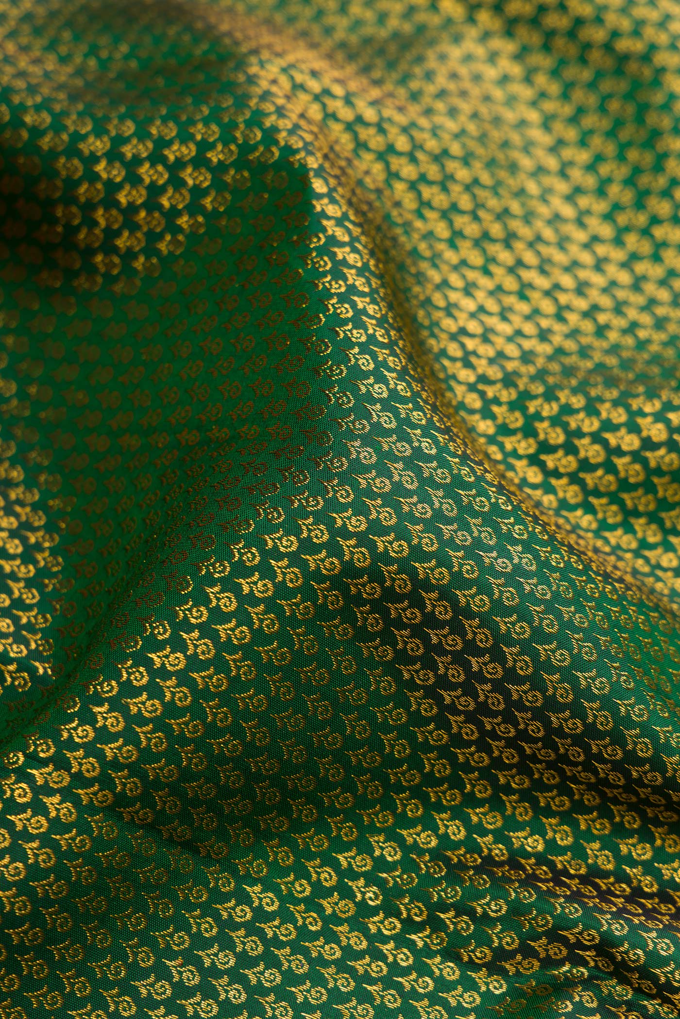 Close up of Green Kanjivaram Silk Saree with Zari Brocade on the body and Zari Border.  displaying folds