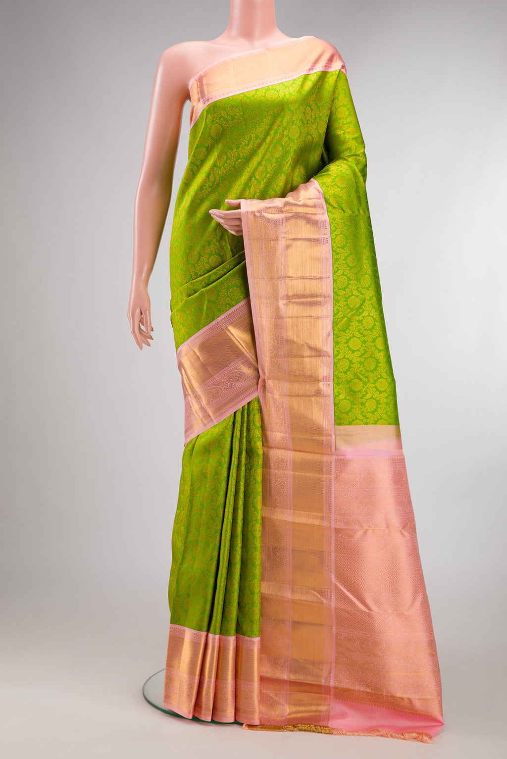Pure Silk Parrot Green Kanjivaram Saree with Zari Brocade on the body and Zari Border.  displayed on a mannequin