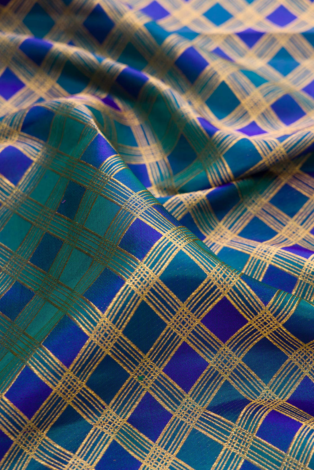 Close up of Pure Silk Peacock Blue Dual Tone Kanjivaram Saree with Checked design on the body and Zari Border.  displaying folds