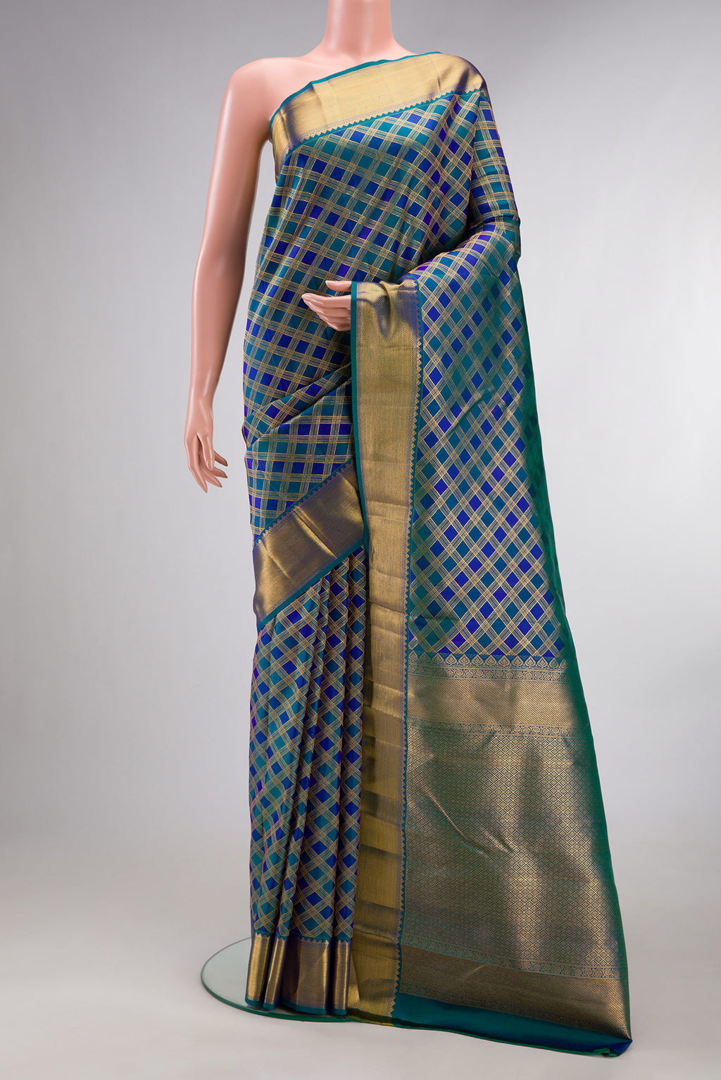 Pure Silk Peacock Blue Dual Tone Kanjivaram Saree with Checked design on the body and Zari Border.  displayed on a mannequin