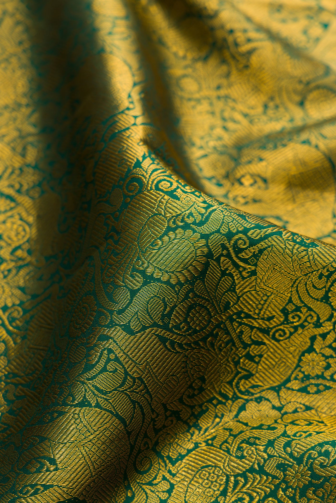 Close up of Green Kanjivaram Silk Saree with Zari Brocade on the body and Zari Border.  displaying folds