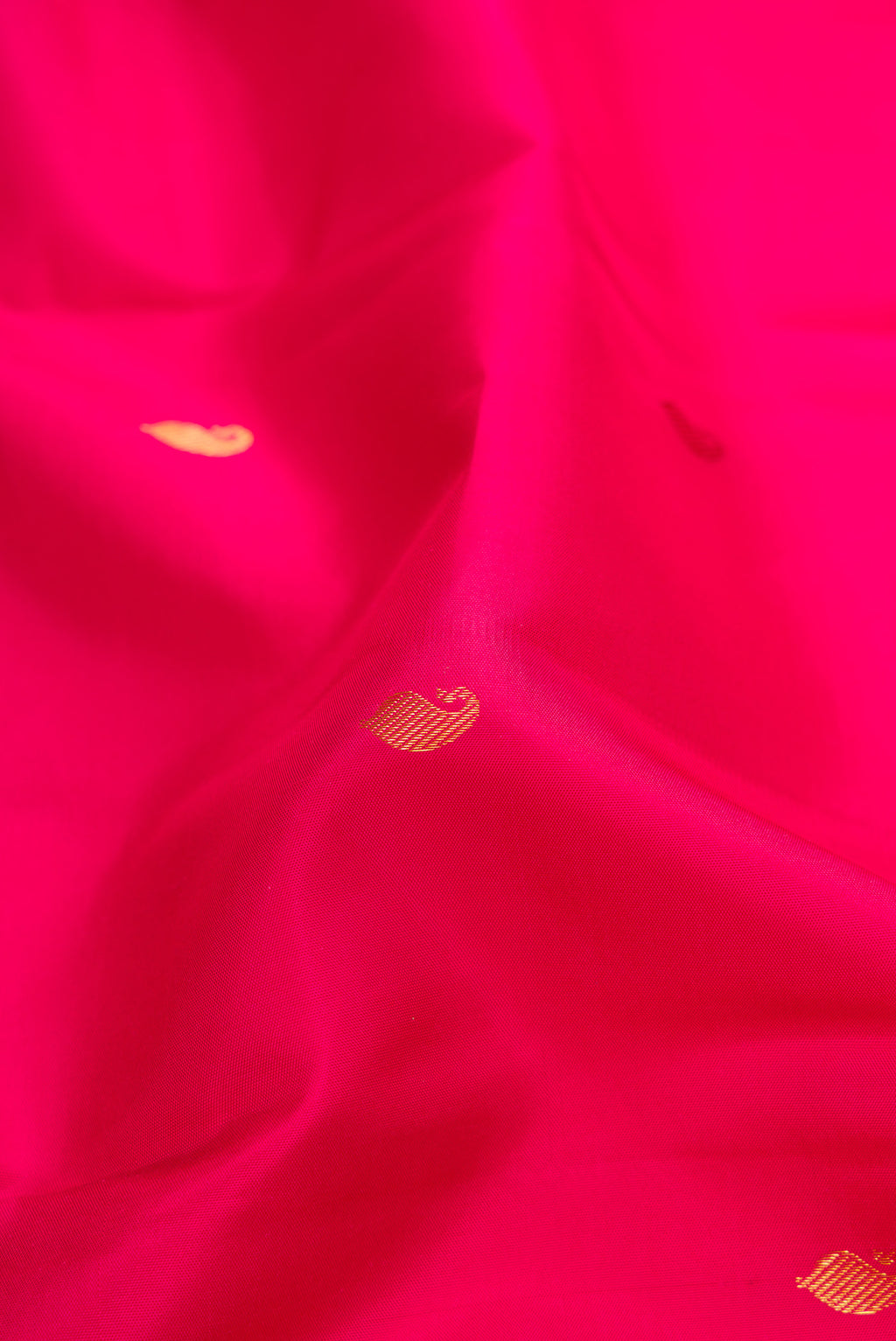 Close up of Dark Pink Kanchipuram Silk Saree with Zari Butta on the body and Zari Border.  displaying folds
