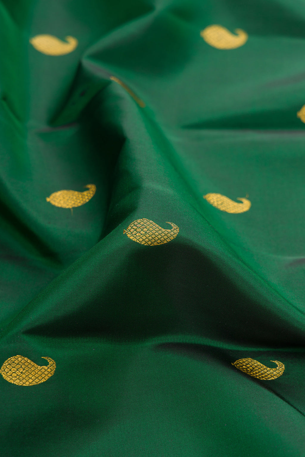 Close up of Bottle Green Kanchipuram Silk Saree with Zari Butta on the body and Zari Border.  displaying folds