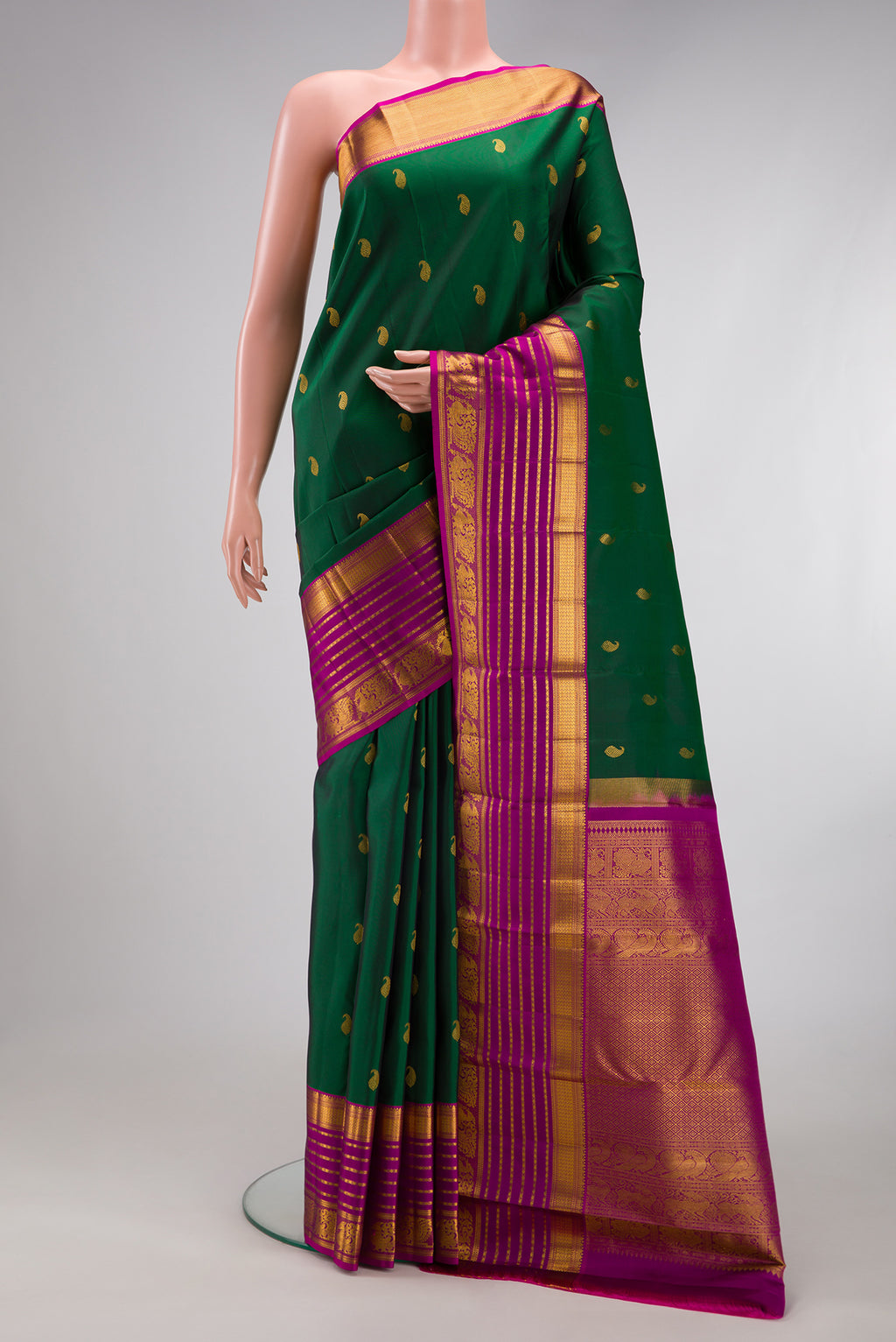 Bottle Green Kanchipuram Silk Saree with Zari Butta on the body and Zari Border.  displayed on a mannequin