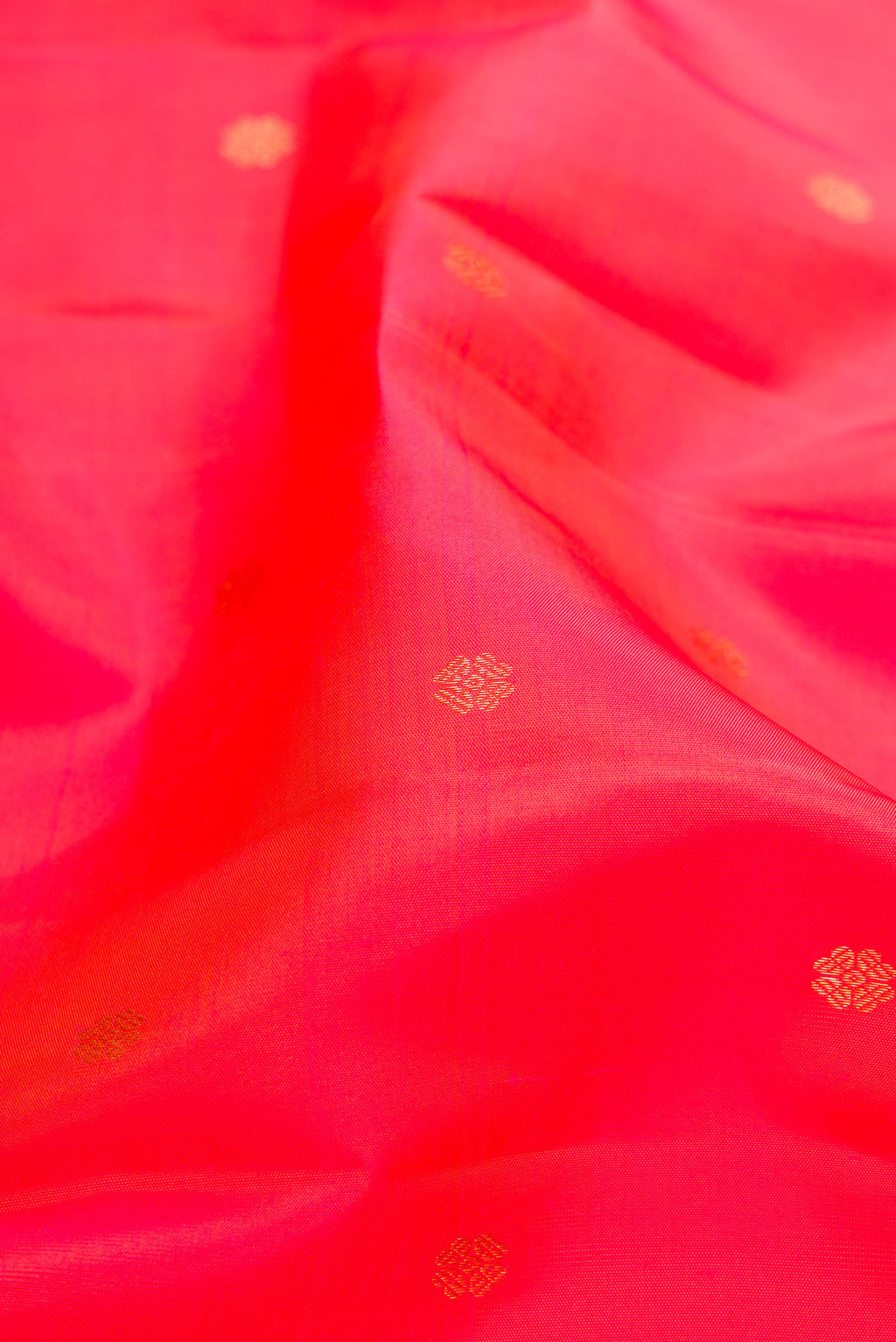 Close up of Coral Dual Tone Kanchipuram Silk Saree with Zari Butta on the body and Fancy Border.  displaying folds