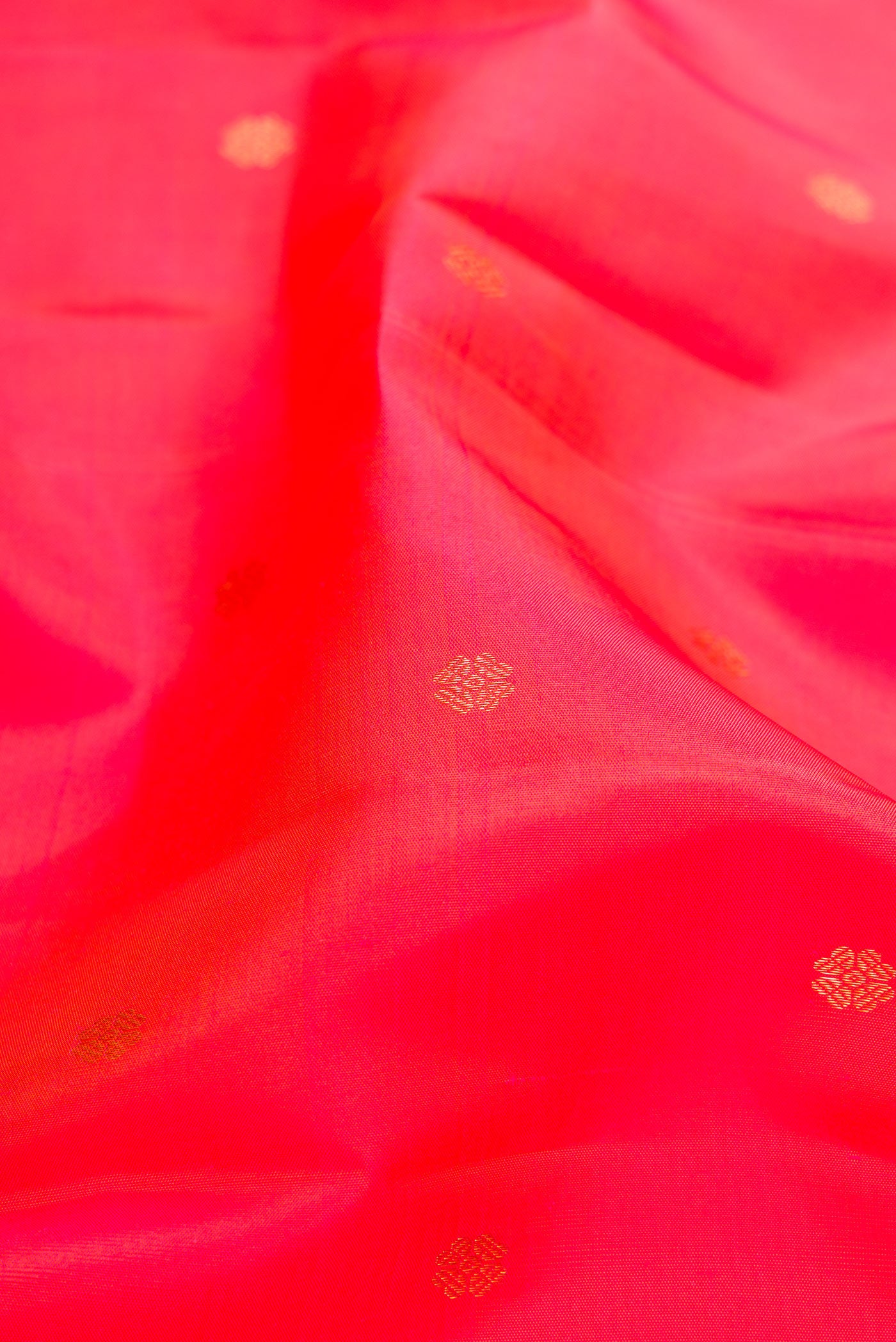 Close up of Coral Dual Tone Kanchipuram Silk Saree with Zari Butta on the body and Fancy Border.  displaying folds
