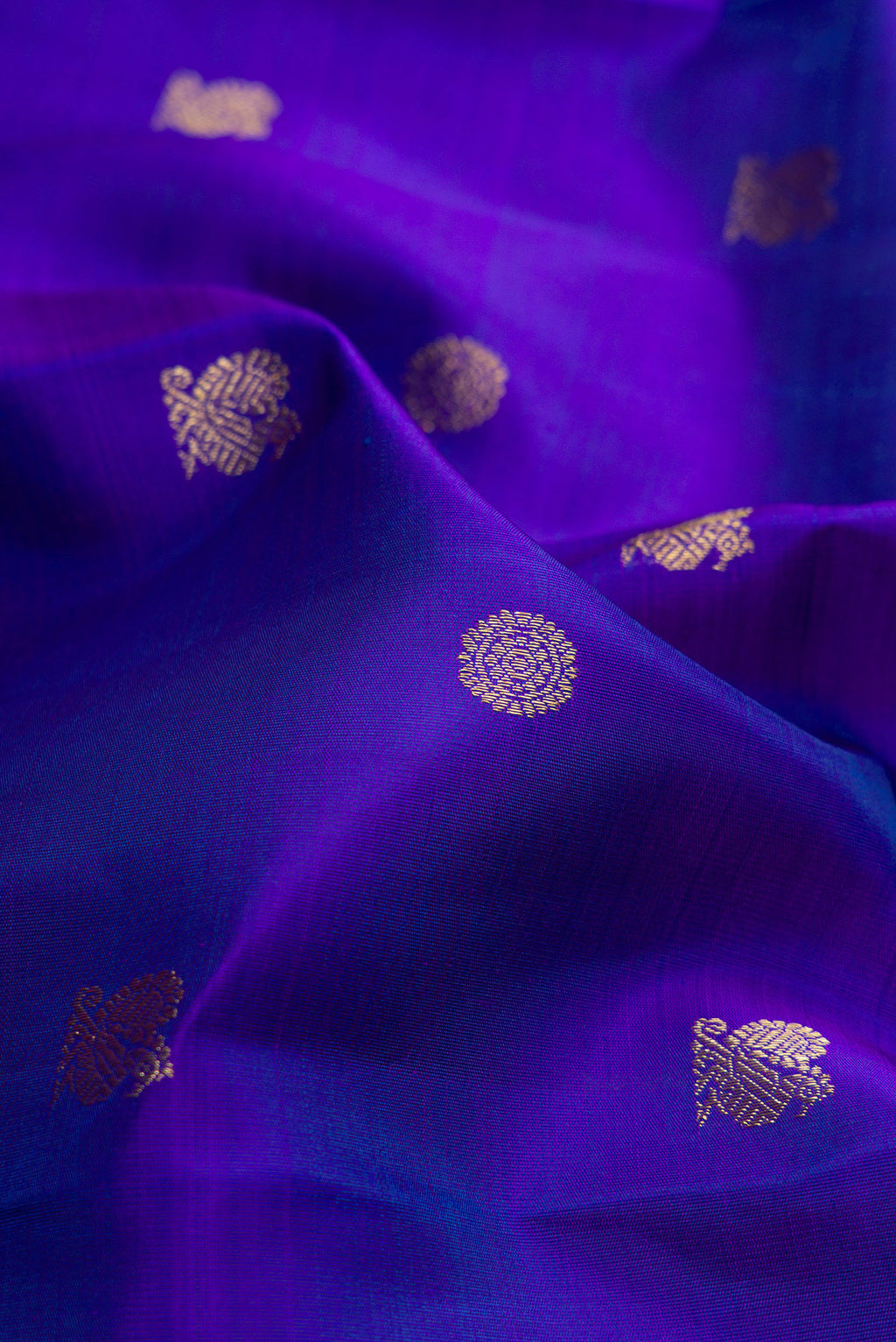 Close up of Pure Silk Pure Zari Royal Blue Kanjivaram Saree with Zari Butta on the body and Zari Border.  displaying folds