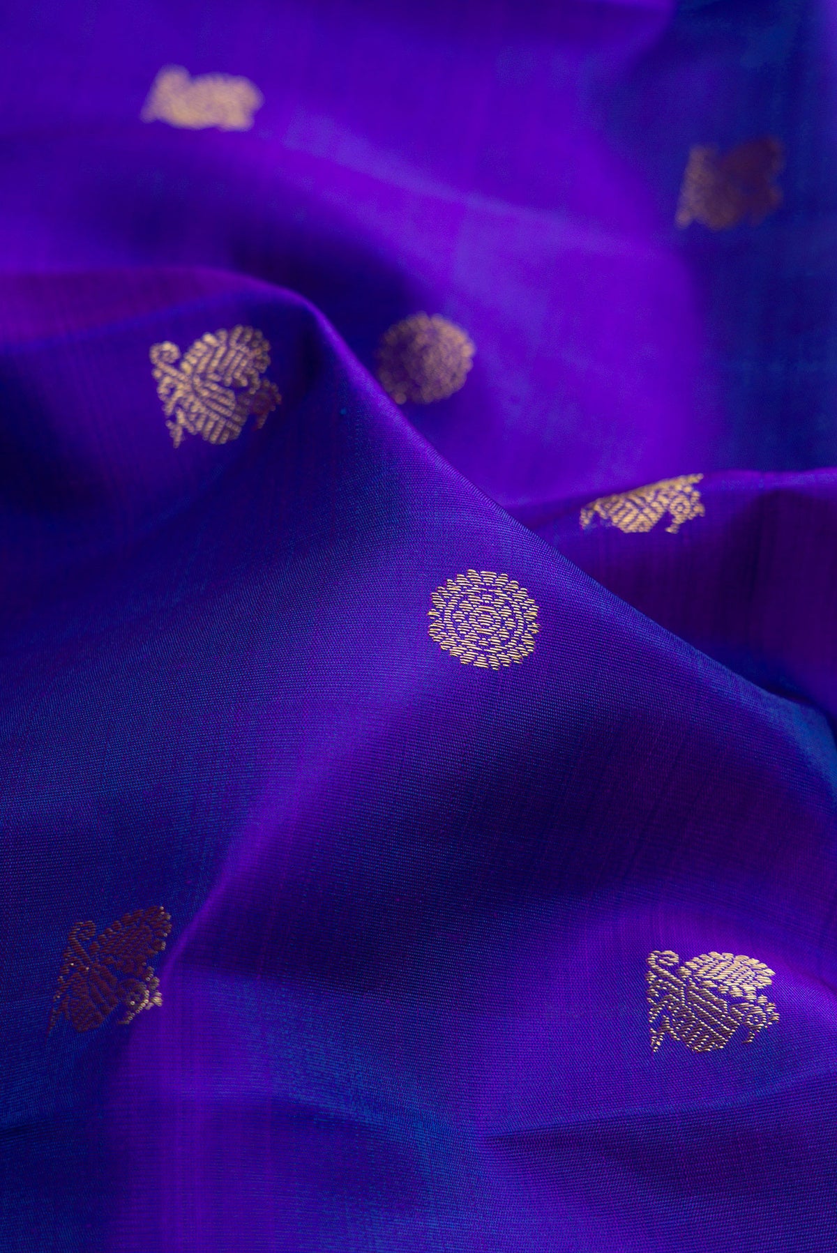 Close up of Pure Silk Pure Zari Royal Blue Kanjivaram Saree with Zari Butta on the body and Zari Border.  displaying folds