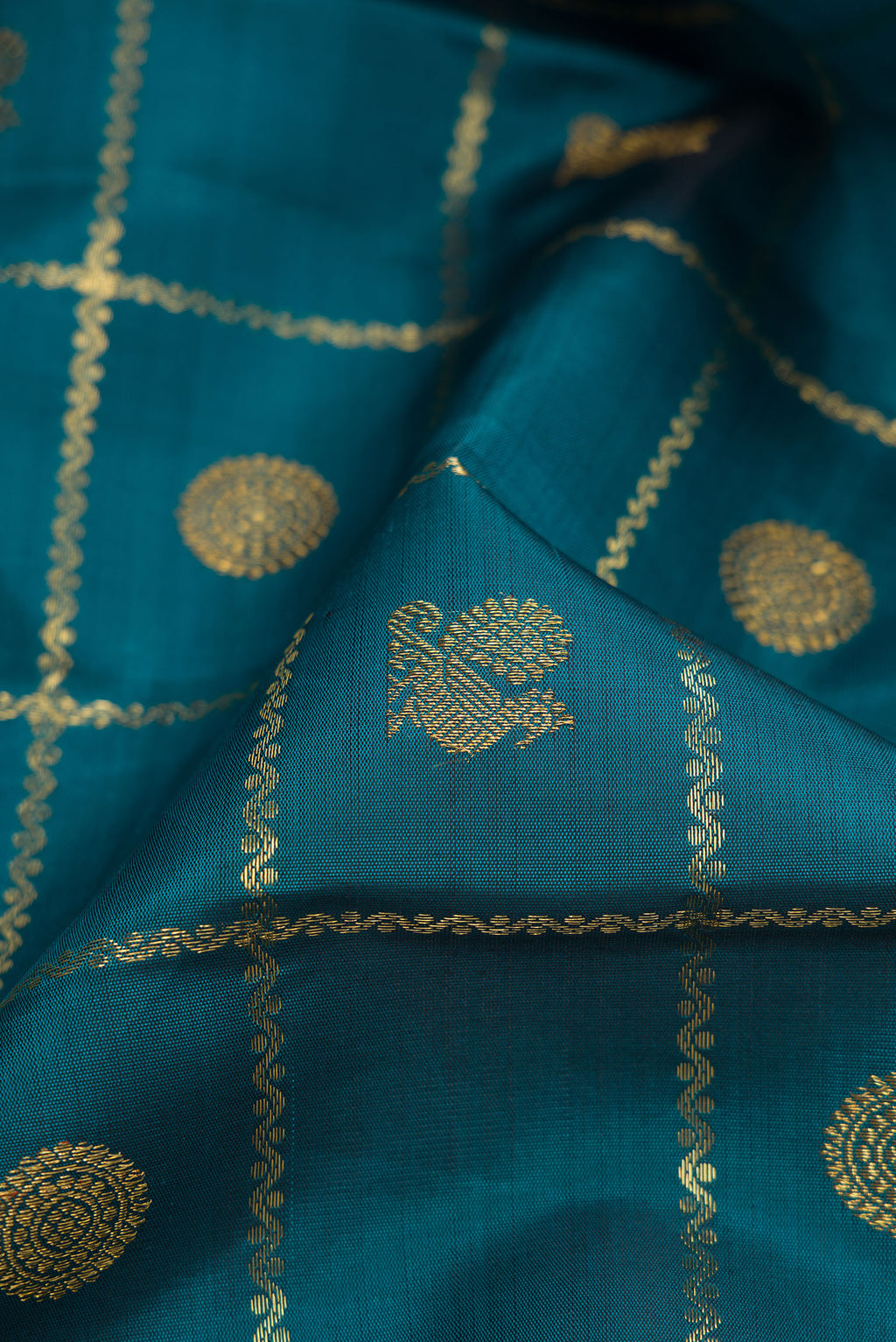 Close up of Pure Silk Pure Zari Peacock Blue Dual Tone Kanjivaram Saree with Checked design on the body and Zari Border.  displaying folds