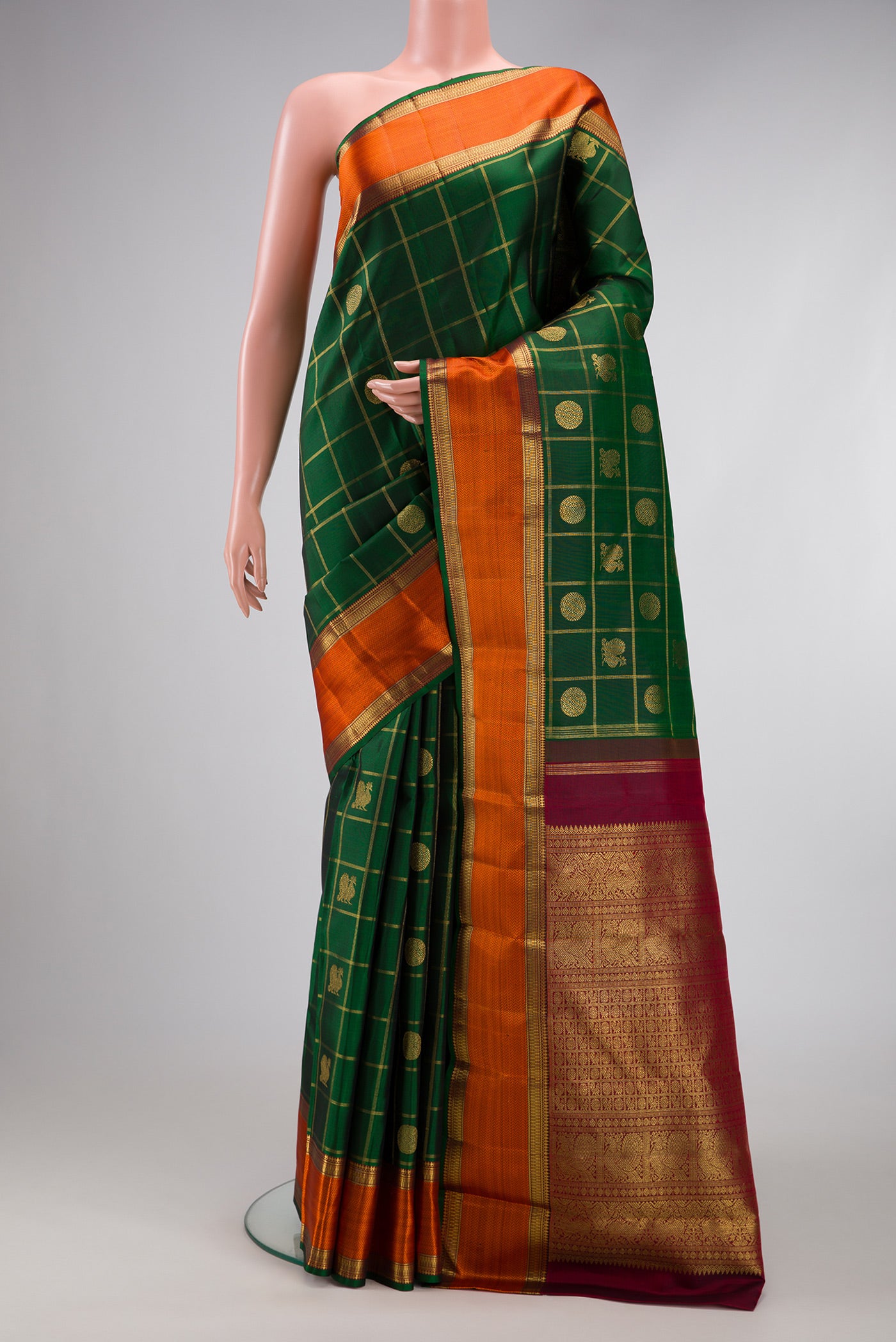 Pure Silk Pure Zari Bottle Green Kanjivaram Saree with Checked design on the body and Zari And Thread Border.  displayed on a mannequin