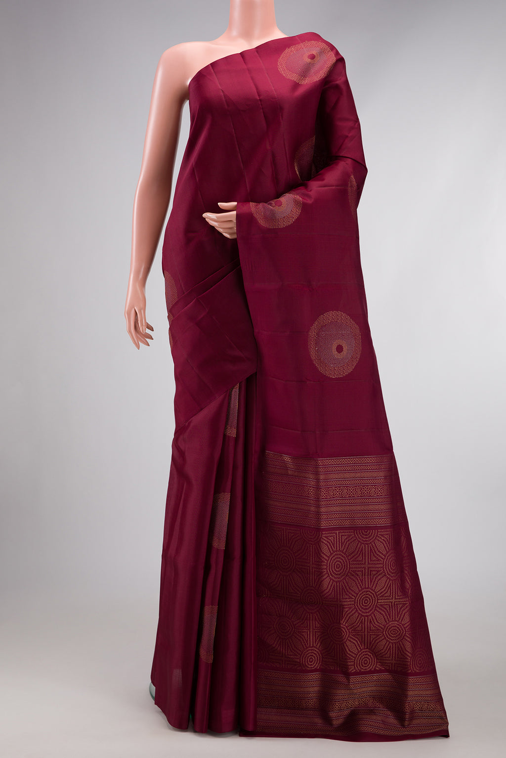 Maroon Soft Silk Saree with Zari Butta on the body and Without Border.  displayed on a mannequin