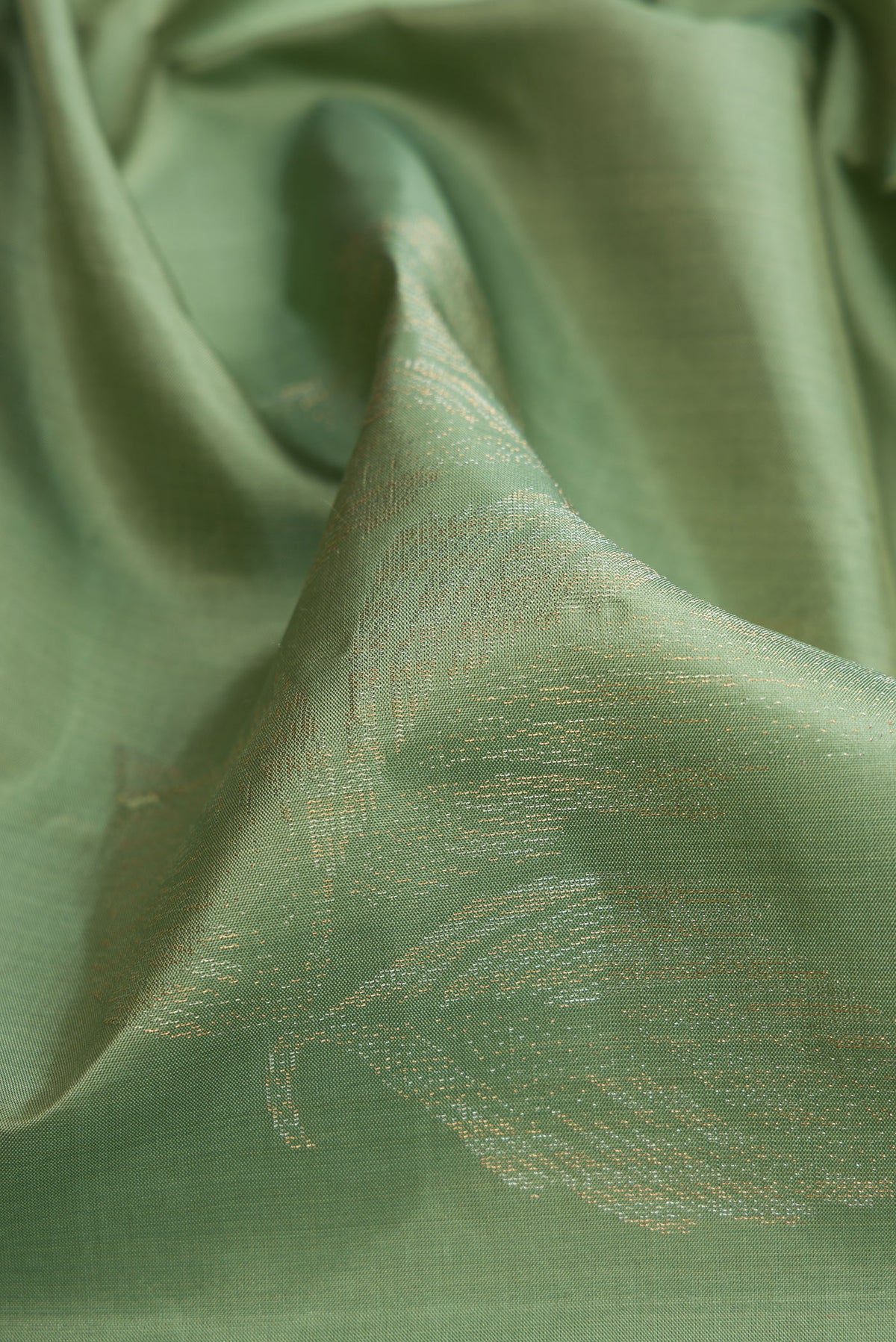 Close up of Pista Green Soft Silk Saree with Zari Butta on the body and Without Border.  displaying folds