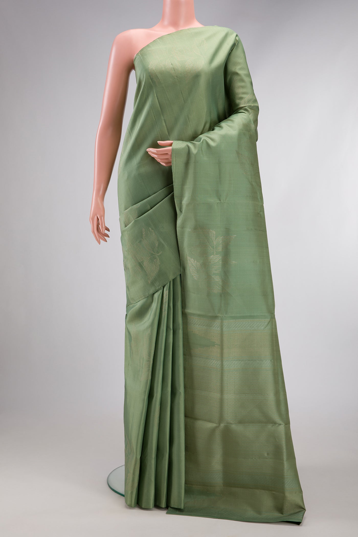 Pista Green Soft Silk Saree with Zari Butta on the body and Without Border.  displayed on a mannequin