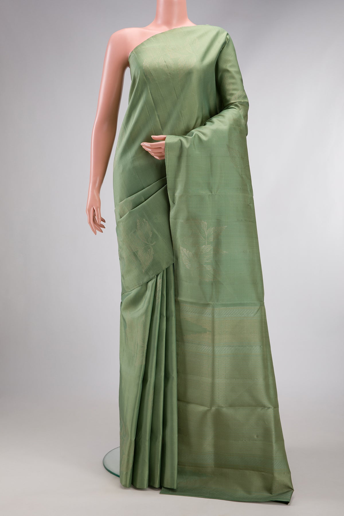 Pista Green Soft Silk Saree with Zari Butta on the body and Without Border.  displayed on a mannequin