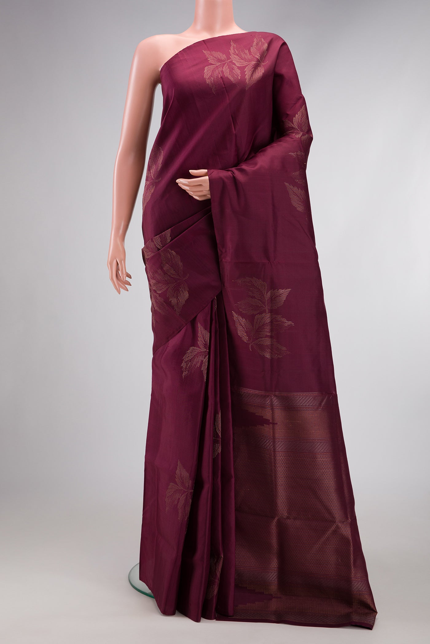 Burgundy Soft Silk Saree with Zari Butta on the body and Without Border.  displayed on a mannequin