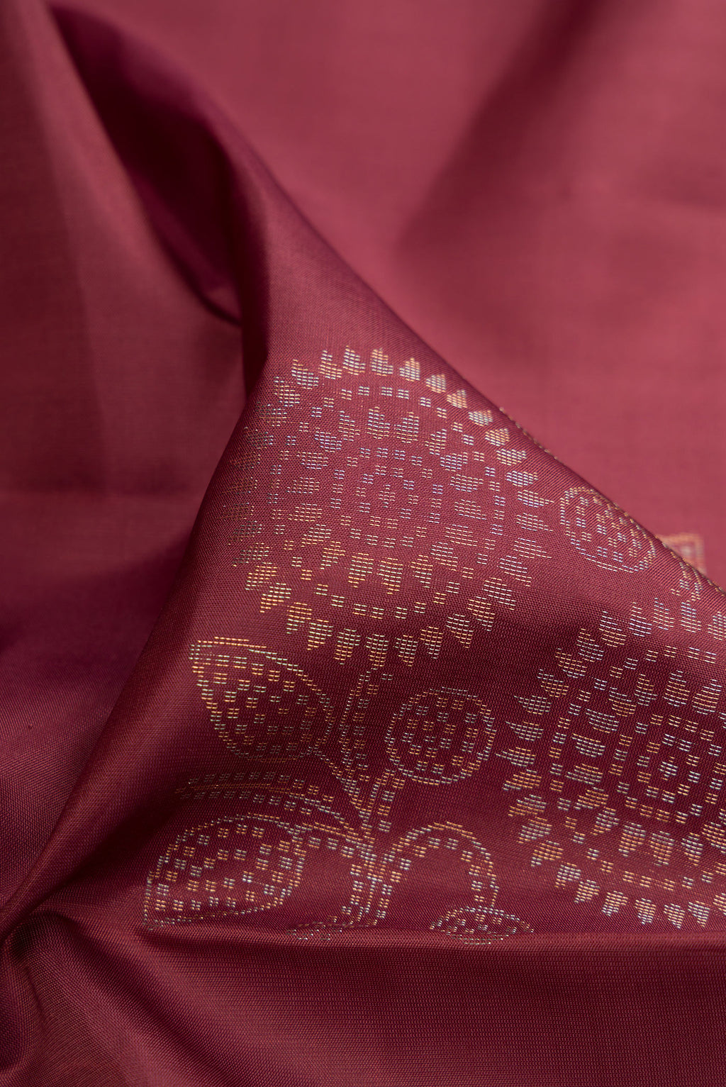 Close up of Dark Mauve Soft Silk Saree with Zari Butta on the body and Without Border.  displaying folds