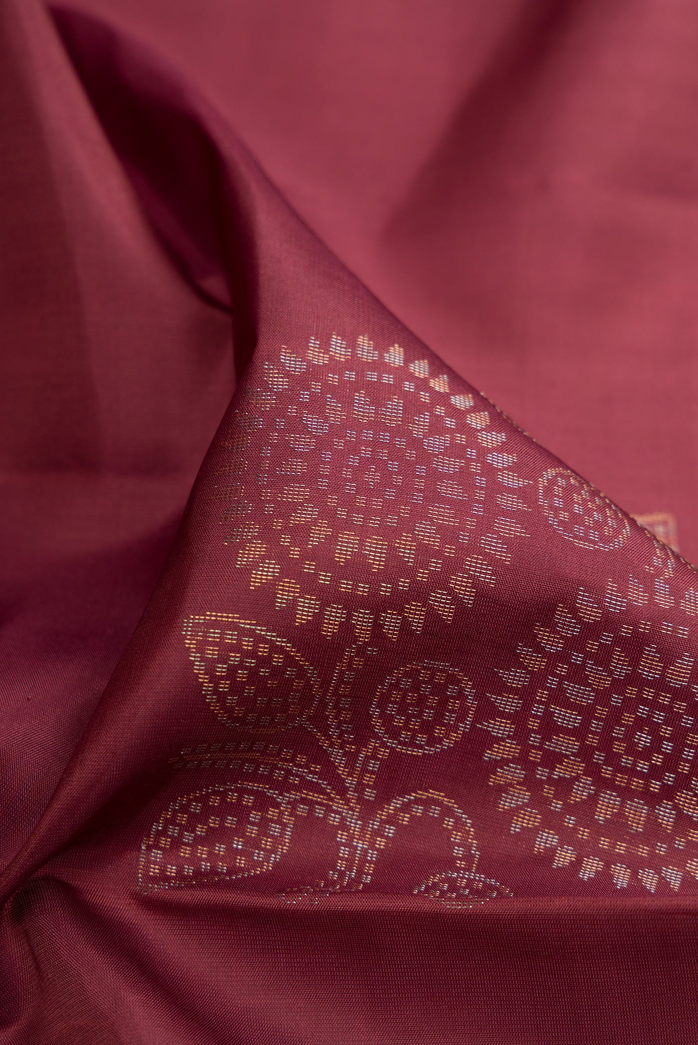 Close up of Dark Mauve Soft Silk Saree with Zari Butta on the body and Without Border.  displaying folds