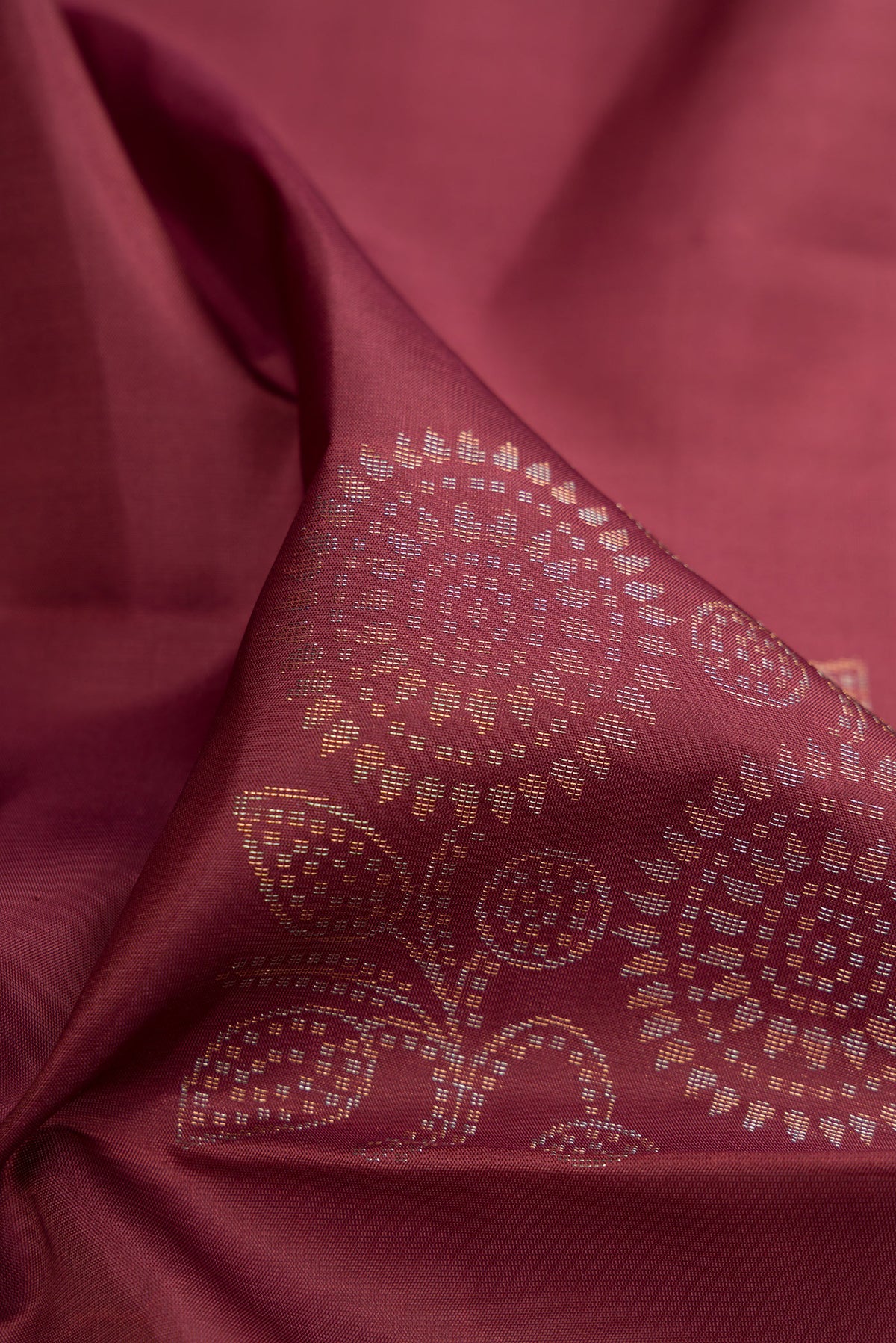 Close up of Dark Mauve Soft Silk Saree with Zari Butta on the body and Without Border.  displaying folds