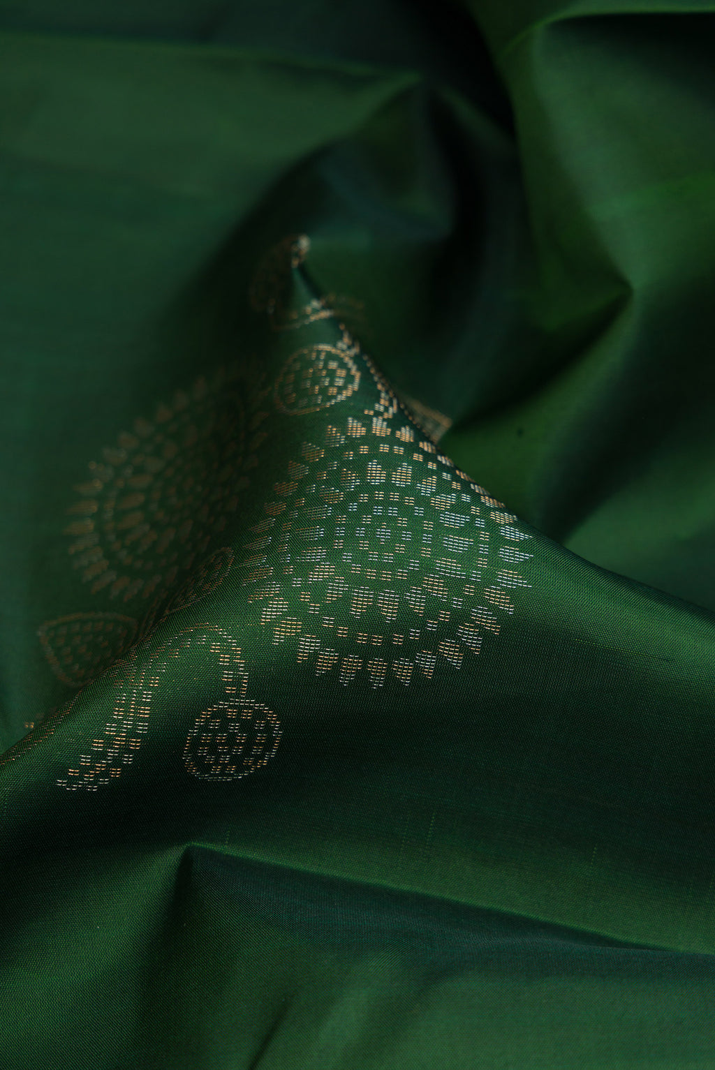 Close up of Bottle Green Soft Silk Saree with Zari Butta on the body and Without Border.  displaying folds