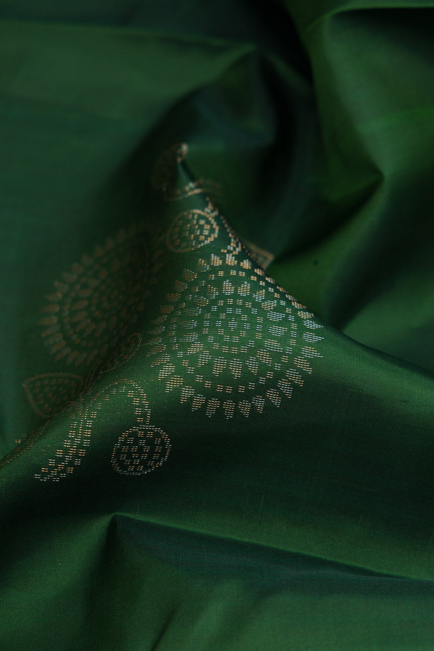 Close up of Bottle Green Soft Silk Saree with Zari Butta on the body and Without Border.  displaying folds