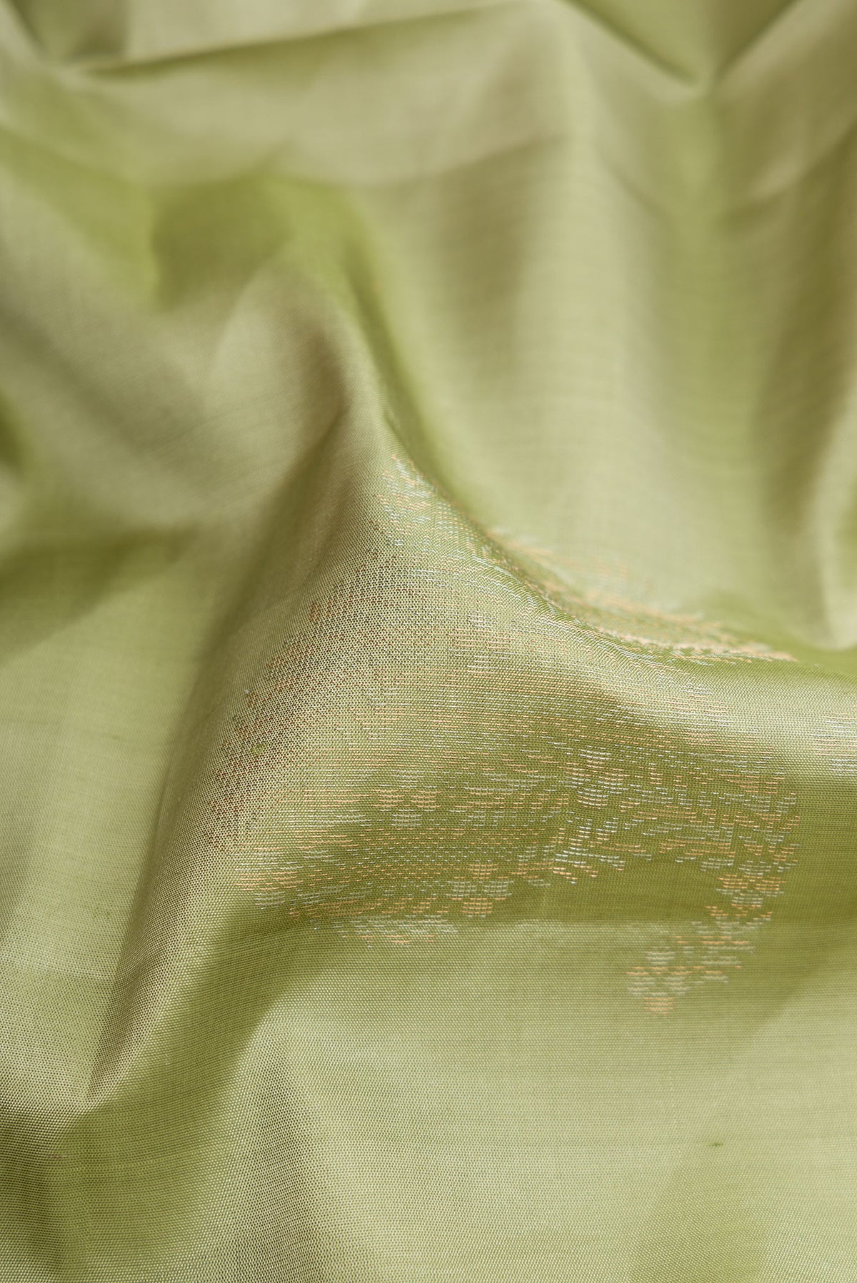 Close up of Pista Green Soft Silk Saree with Zari Butta on the body and Without Border.  displaying folds