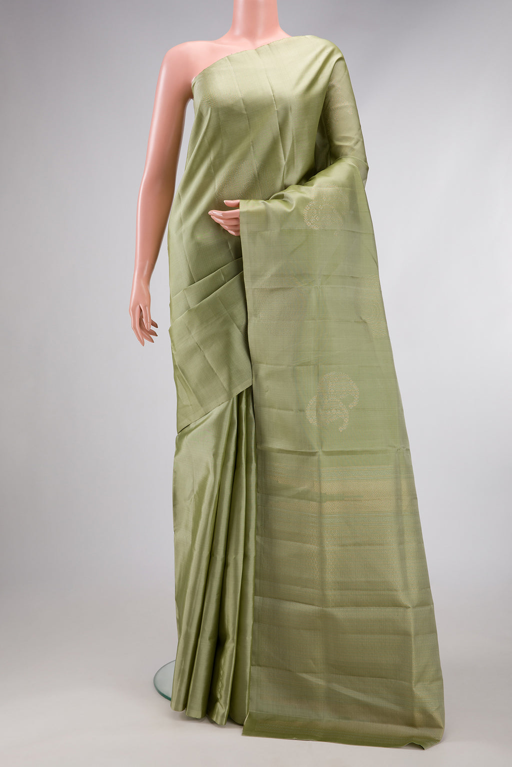 Pista Green Soft Silk Saree with Zari Butta on the body and Without Border.  displayed on a mannequin