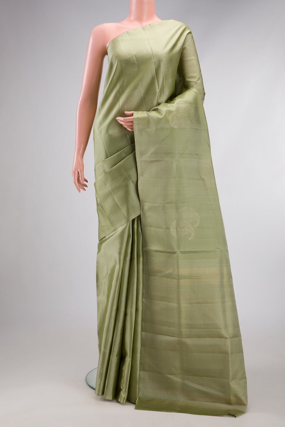 Pista Green Soft Silk Saree with Zari Butta on the body and Without Border.  displayed on a mannequin