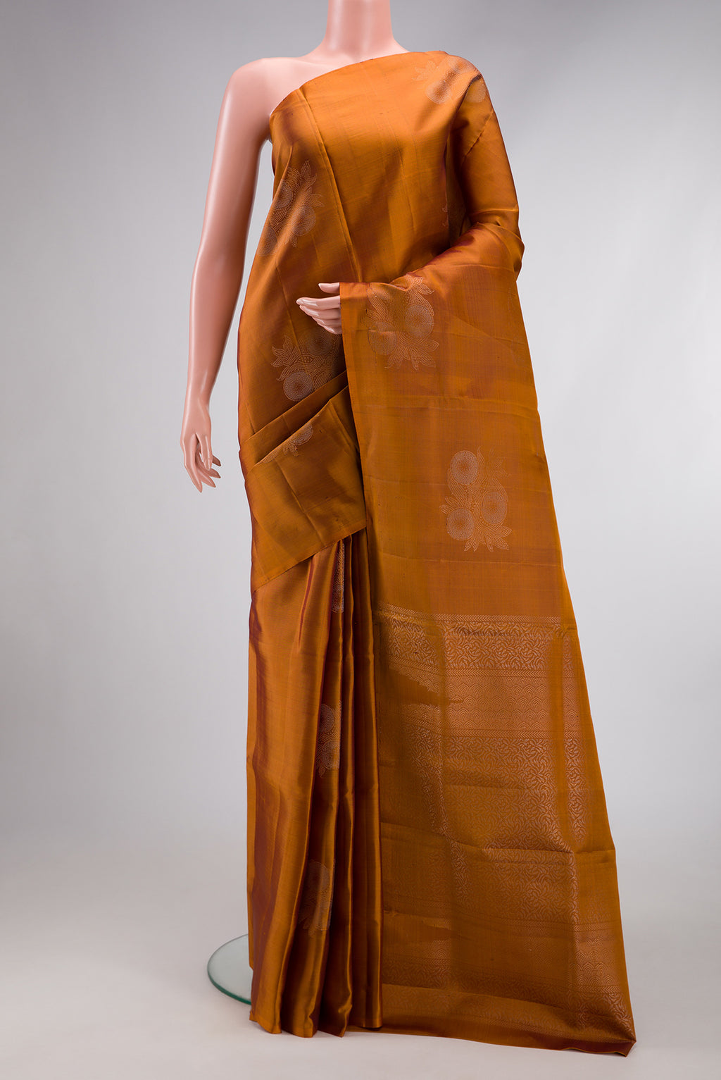 Mustard Soft Silk Saree with Zari Butta on the body and Without Border.  displayed on a mannequin