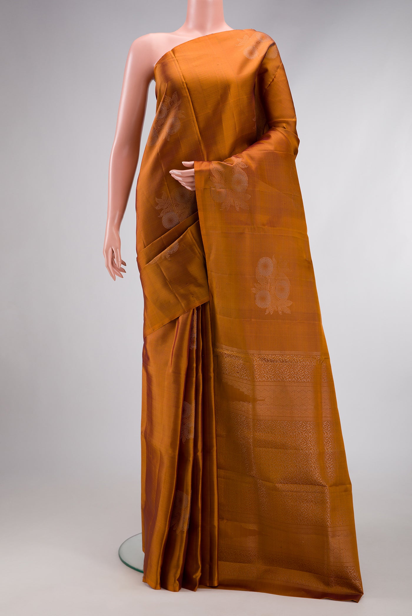 Mustard Soft Silk Saree with Zari Butta on the body and Without Border.  displayed on a mannequin