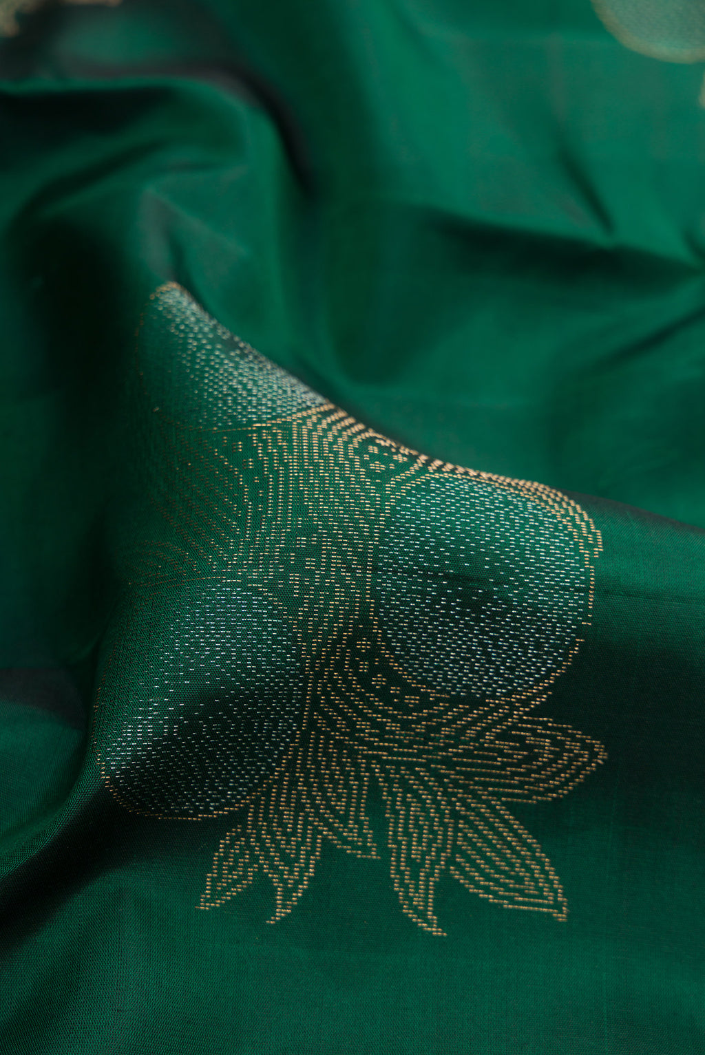 Close up of Bottle Green Soft Silk Saree with Zari Butta on the body and Without Border.  displaying folds