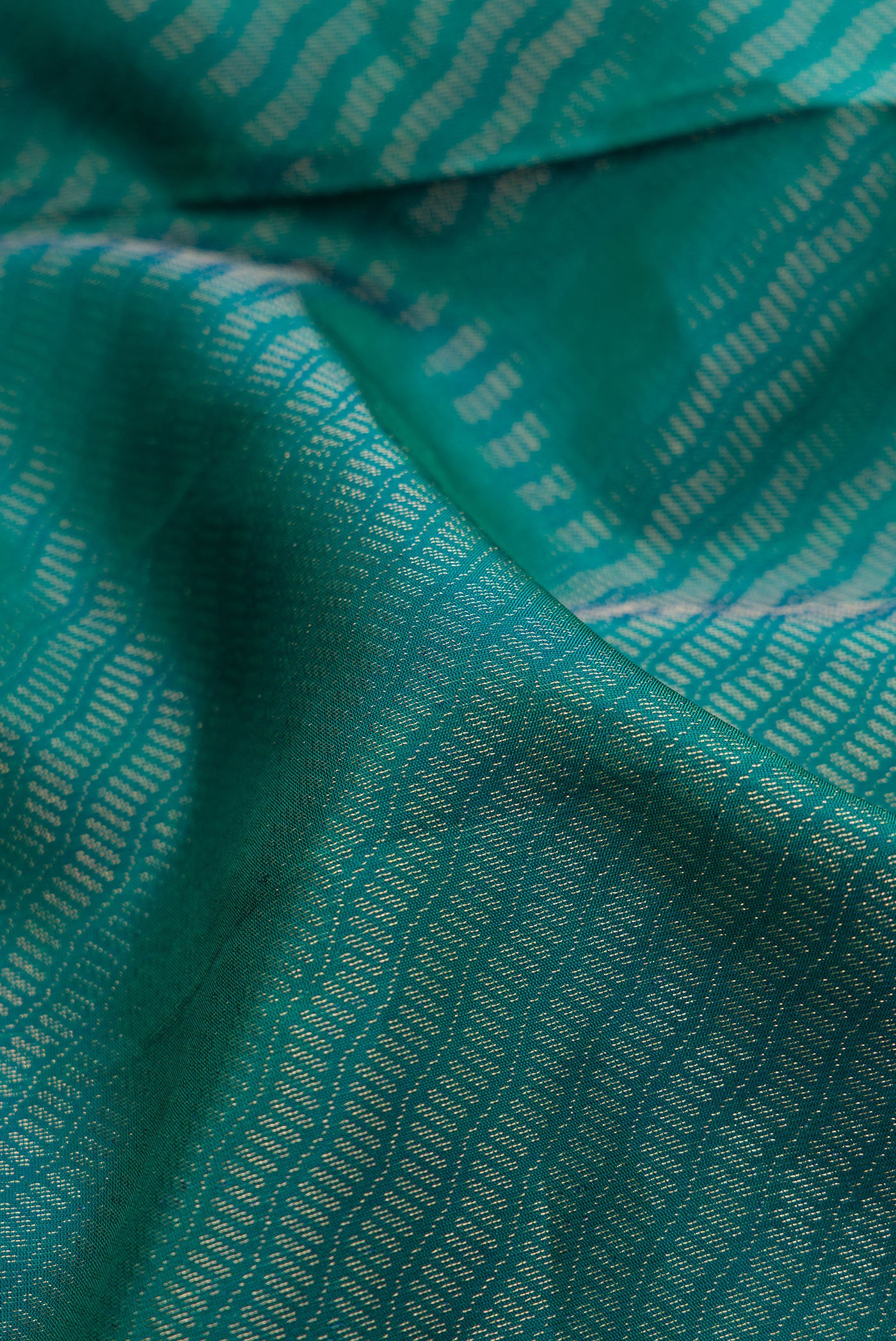Close up of Peacock Blue Dual Tone Soft Silk Saree with Zari Brocade on the body and Fancy Border.  displaying folds