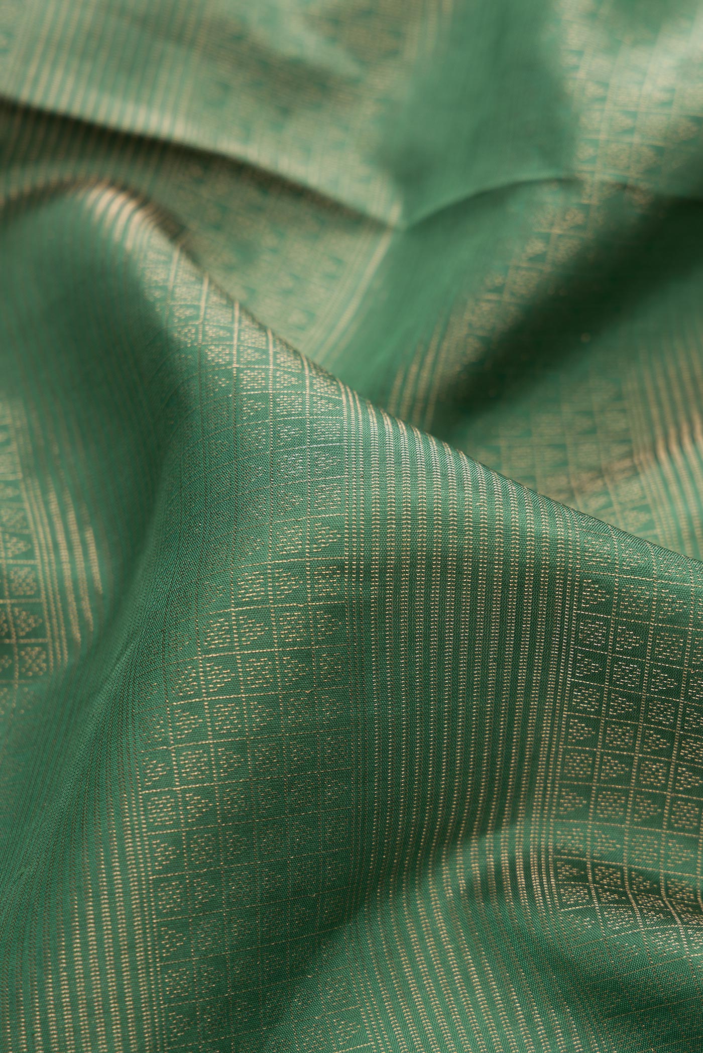 Close up of Green Soft Silk Saree with Zari Brocade on the body and Fancy Border.  displaying folds