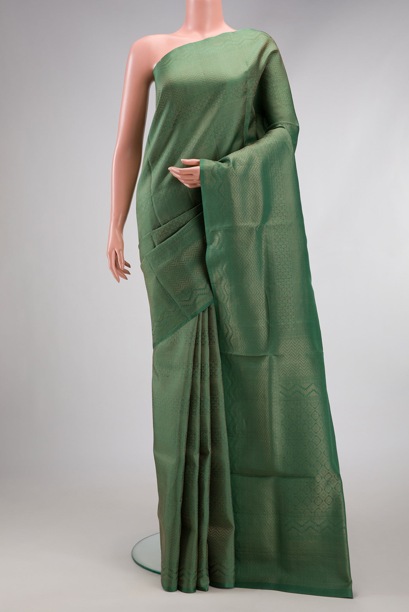 Green Soft Silk Saree with Zari Brocade on the body and Fancy Border.  displayed on a mannequin