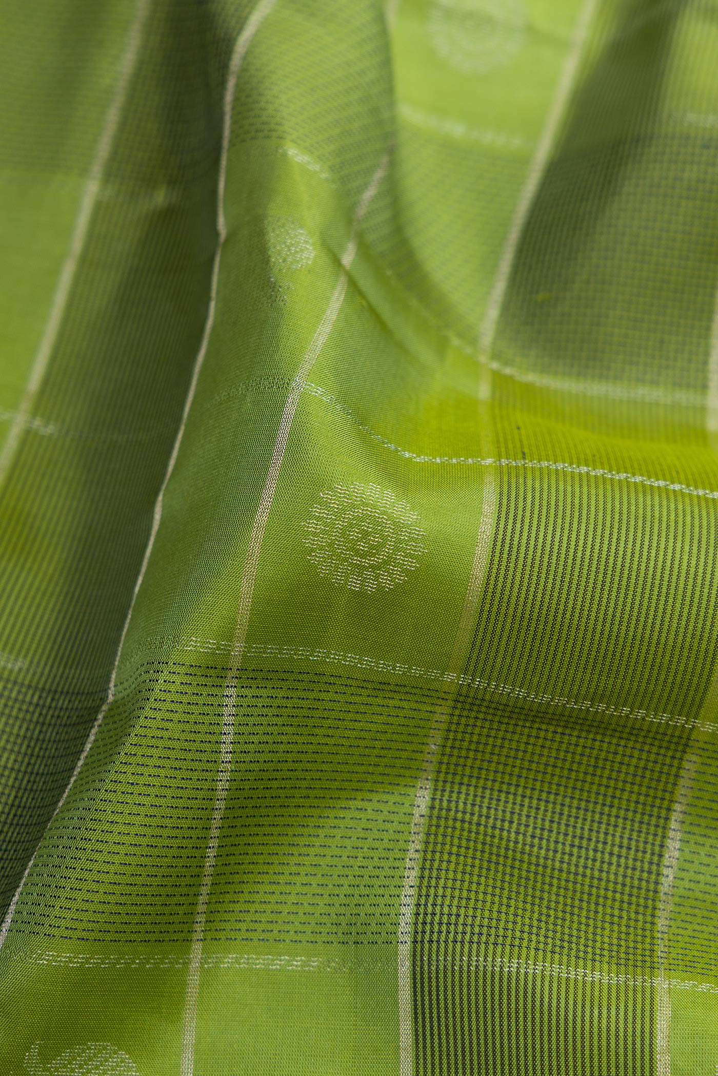 Close up of Green Soft Silk Saree with Checked design on the body and Plain Border.  displaying folds