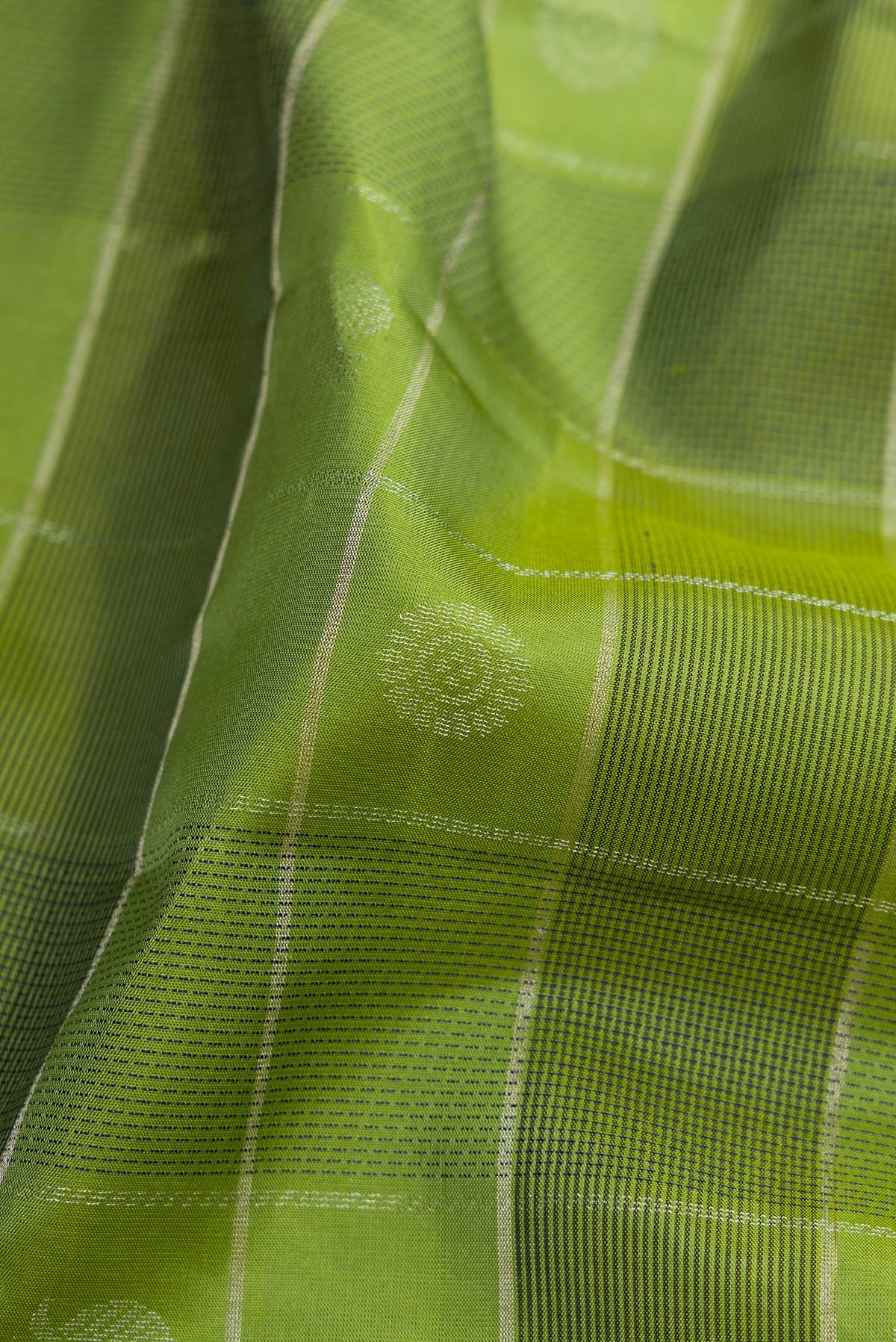 Close up of Green Soft Silk Saree with Checked design on the body and Plain Border.  displaying folds