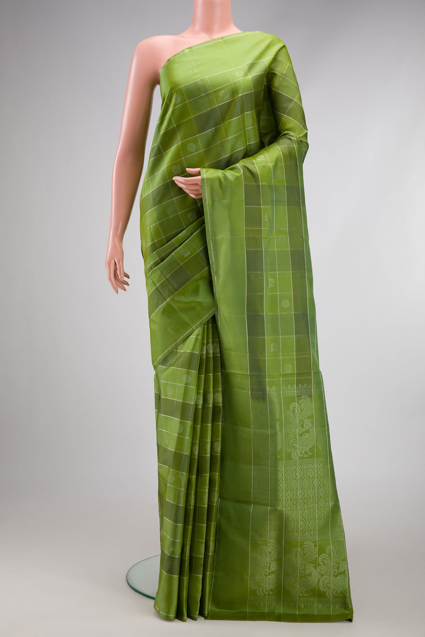 Green Soft Silk Saree with Checked design on the body and Plain Border.  displayed on a mannequin