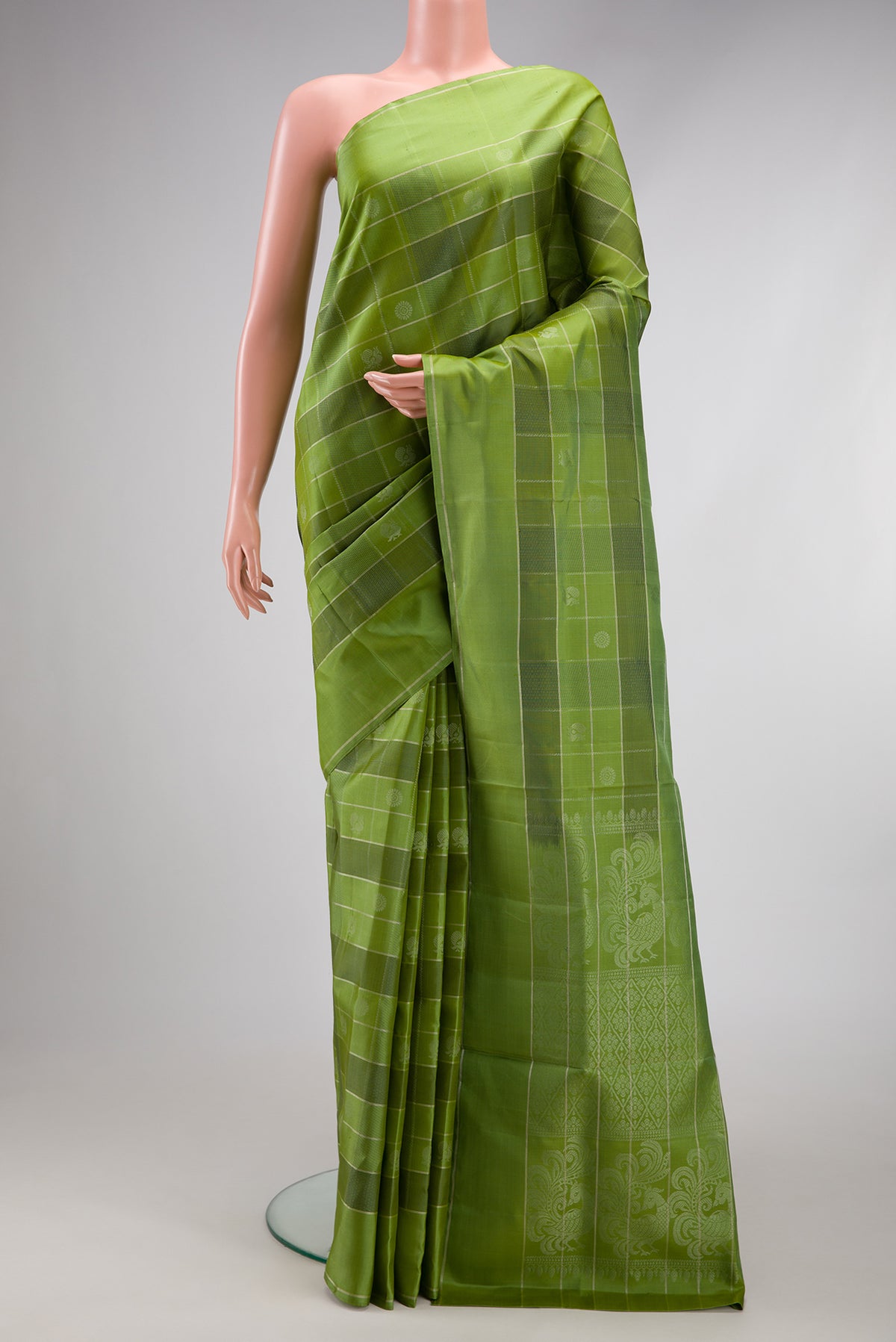 Green Soft Silk Saree with Checked design on the body and Plain Border.  displayed on a mannequin