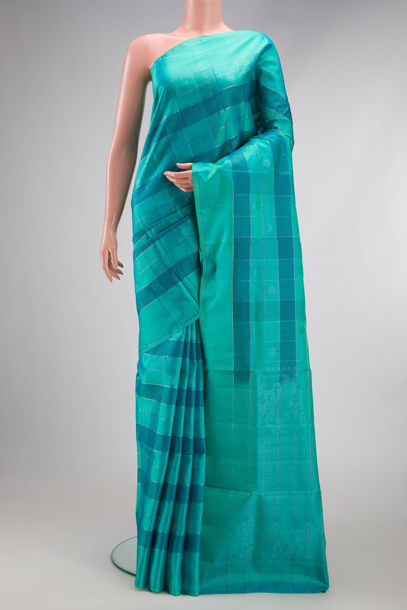 Sea Green Soft Silk Saree with Checked design on the body and Plain Border.  displayed on a mannequin
