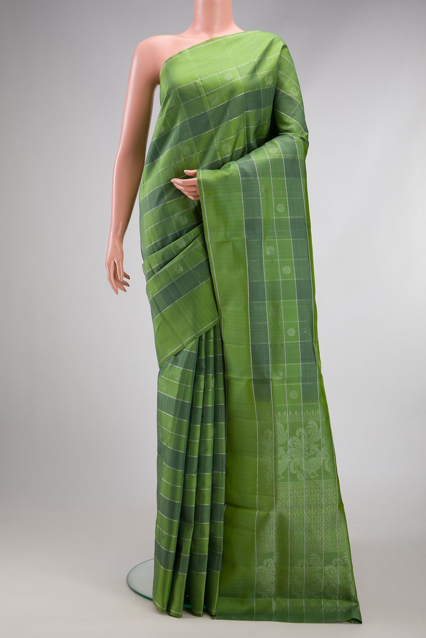 Green Soft Silk Saree with Checked design on the body and Plain Border.  displayed on a mannequin
