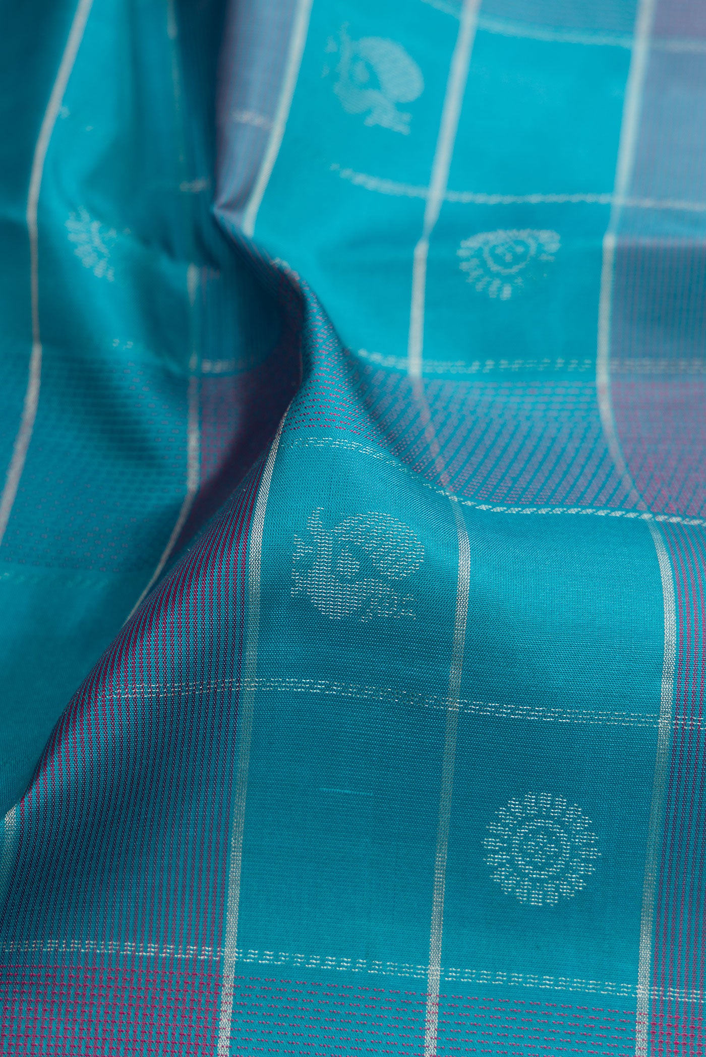 Close up of Sky Blue Soft Silk Saree with Checked design on the body and Plain Border.  displaying folds