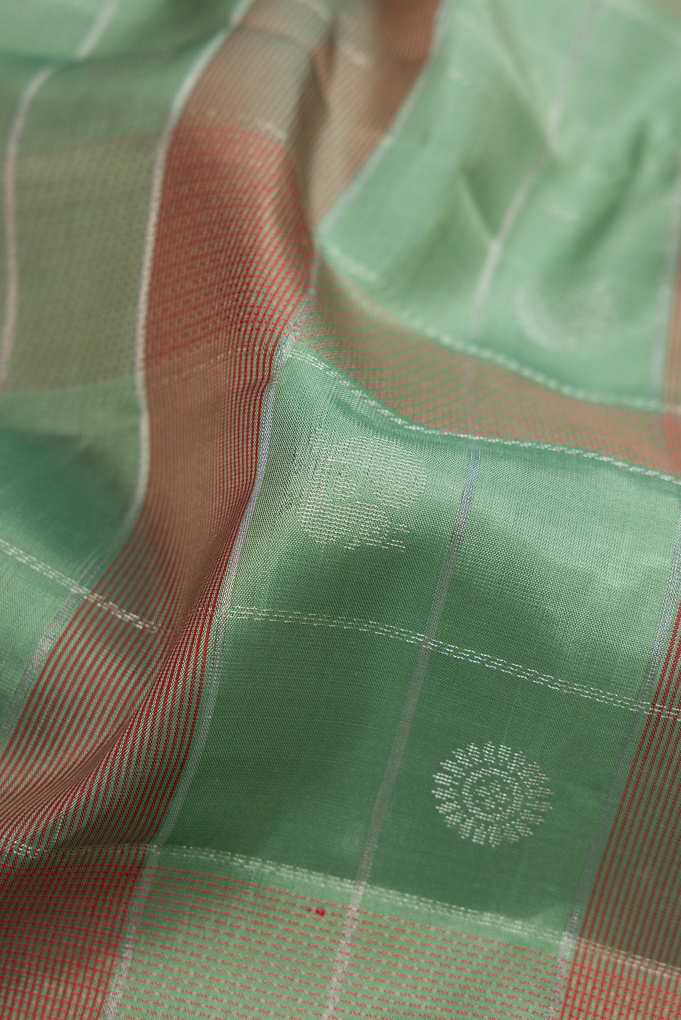 Close up of Sage Green Soft Silk Saree with Checked design on the body and Plain Border.  displaying folds